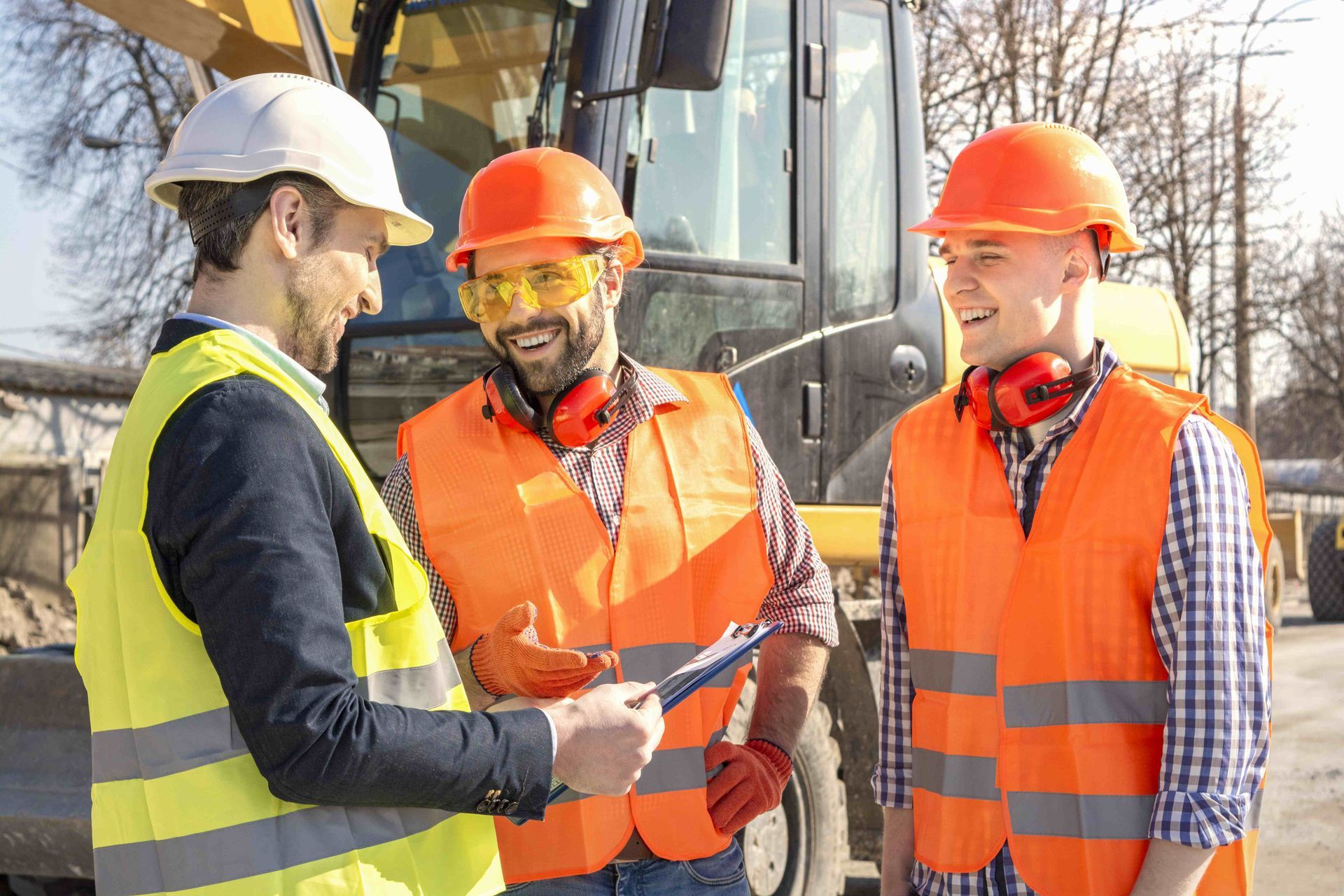 three construction workers wearing orange vests and hard hats are talking to each other