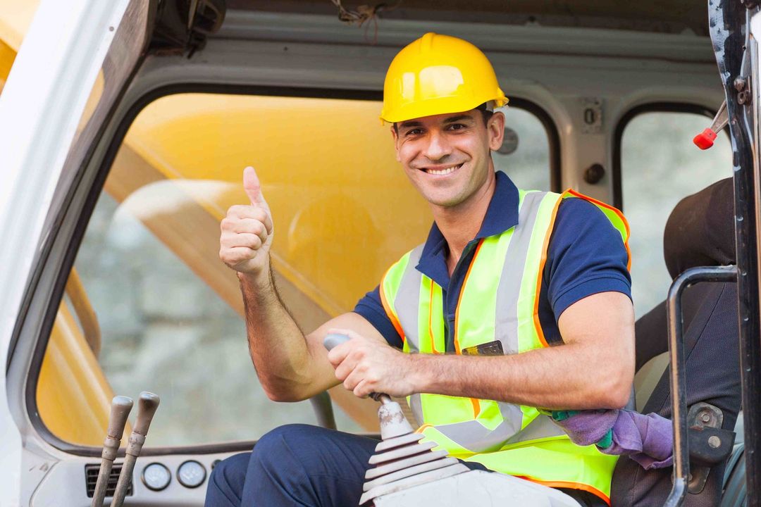 a man wearing a yellow hard hat is giving a thumbs up