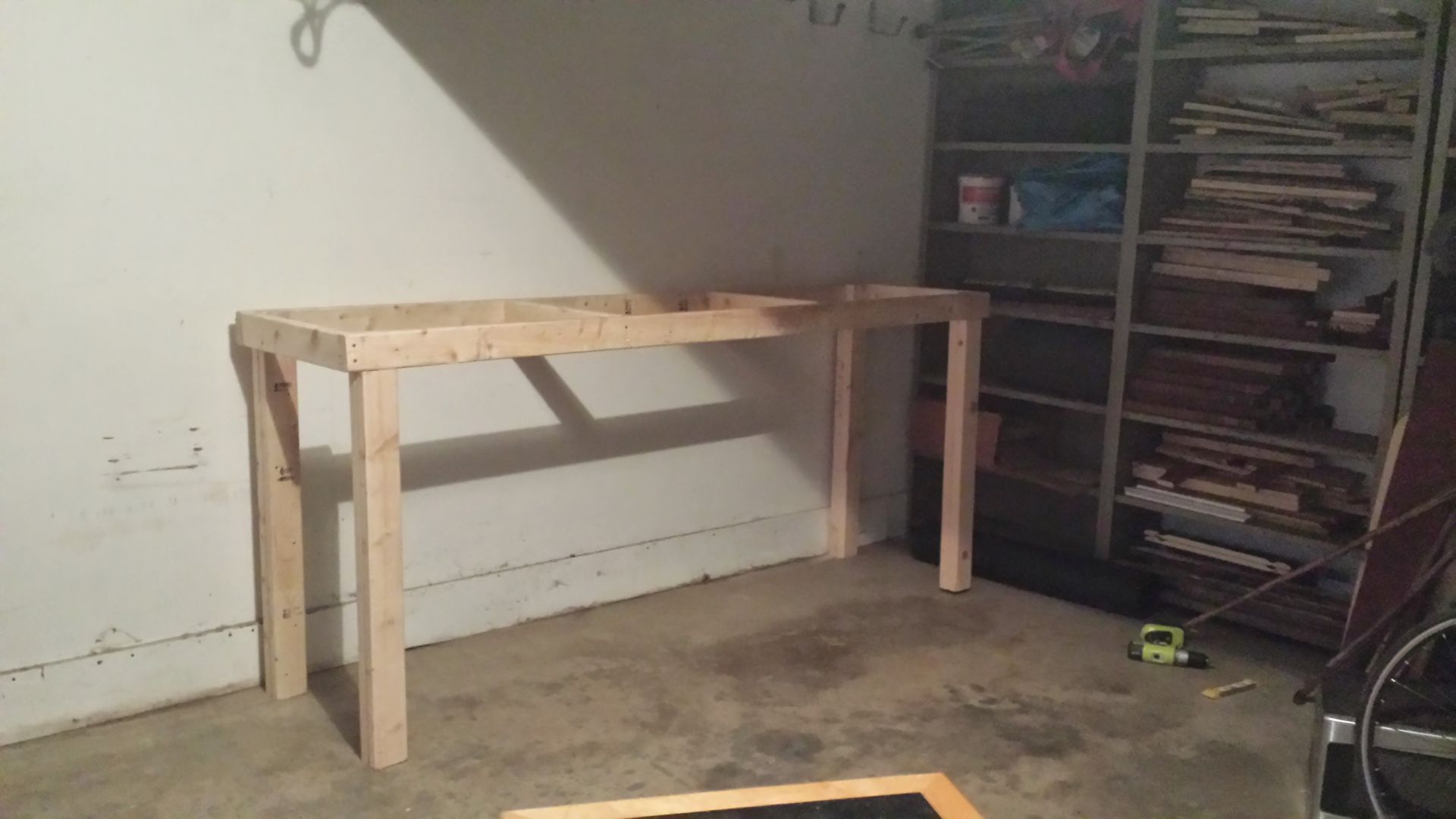 A wooden table is sitting in a room next to a shelf.