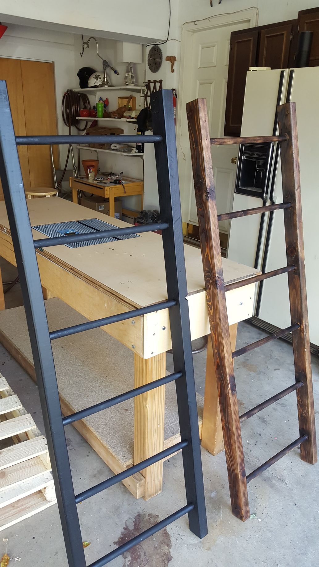 Two ladders are sitting on top of a wooden table in a garage.