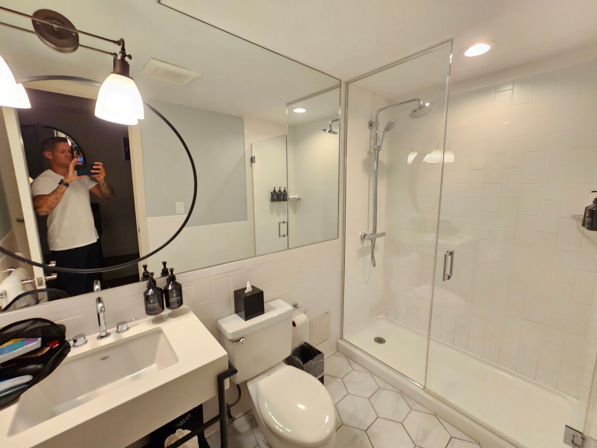 A man is taking a picture of himself in a bathroom.