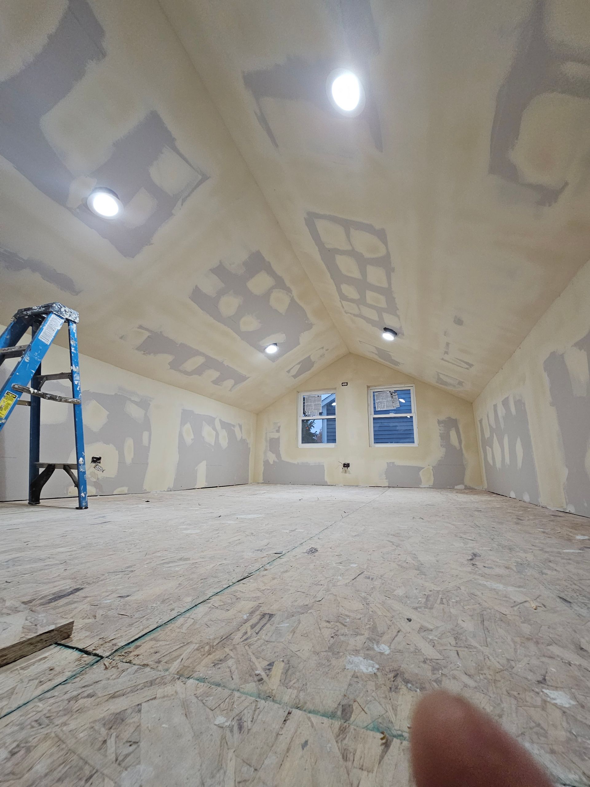 An empty room with a ladder in the corner