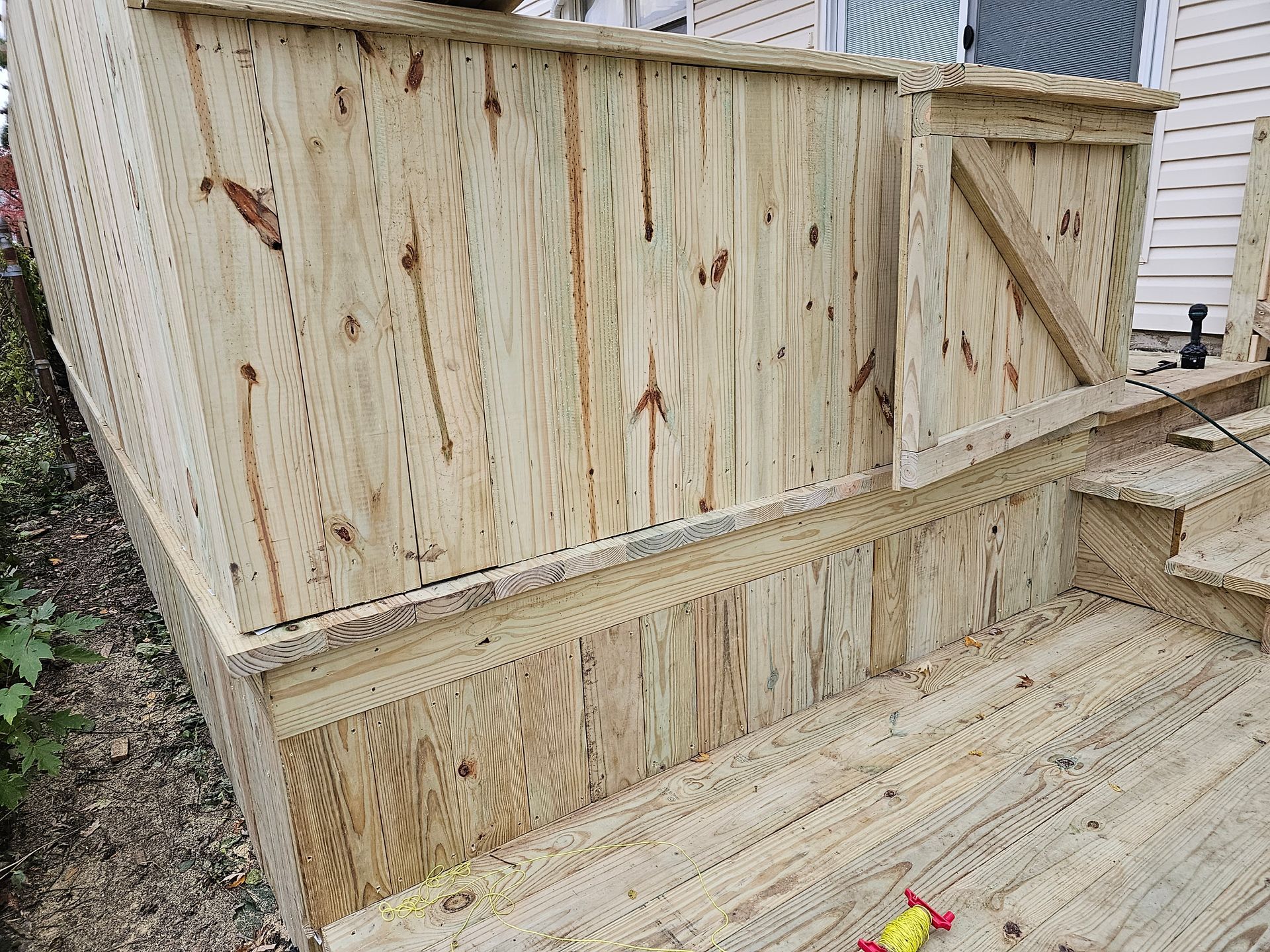 A wooden deck with stairs and a wooden fence.