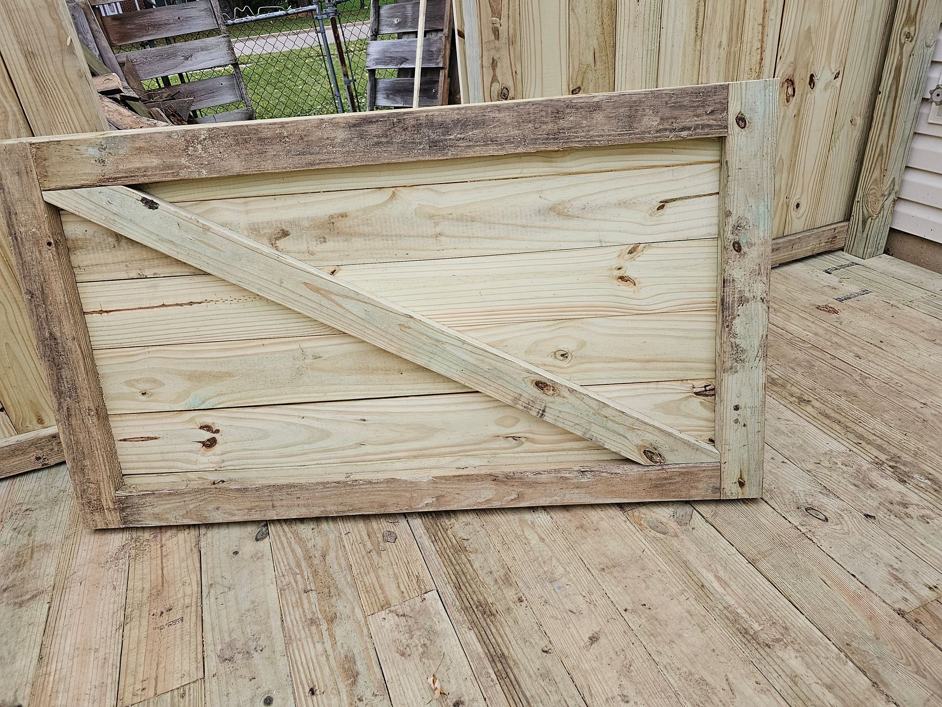 A wooden gate is sitting on top of a wooden deck.