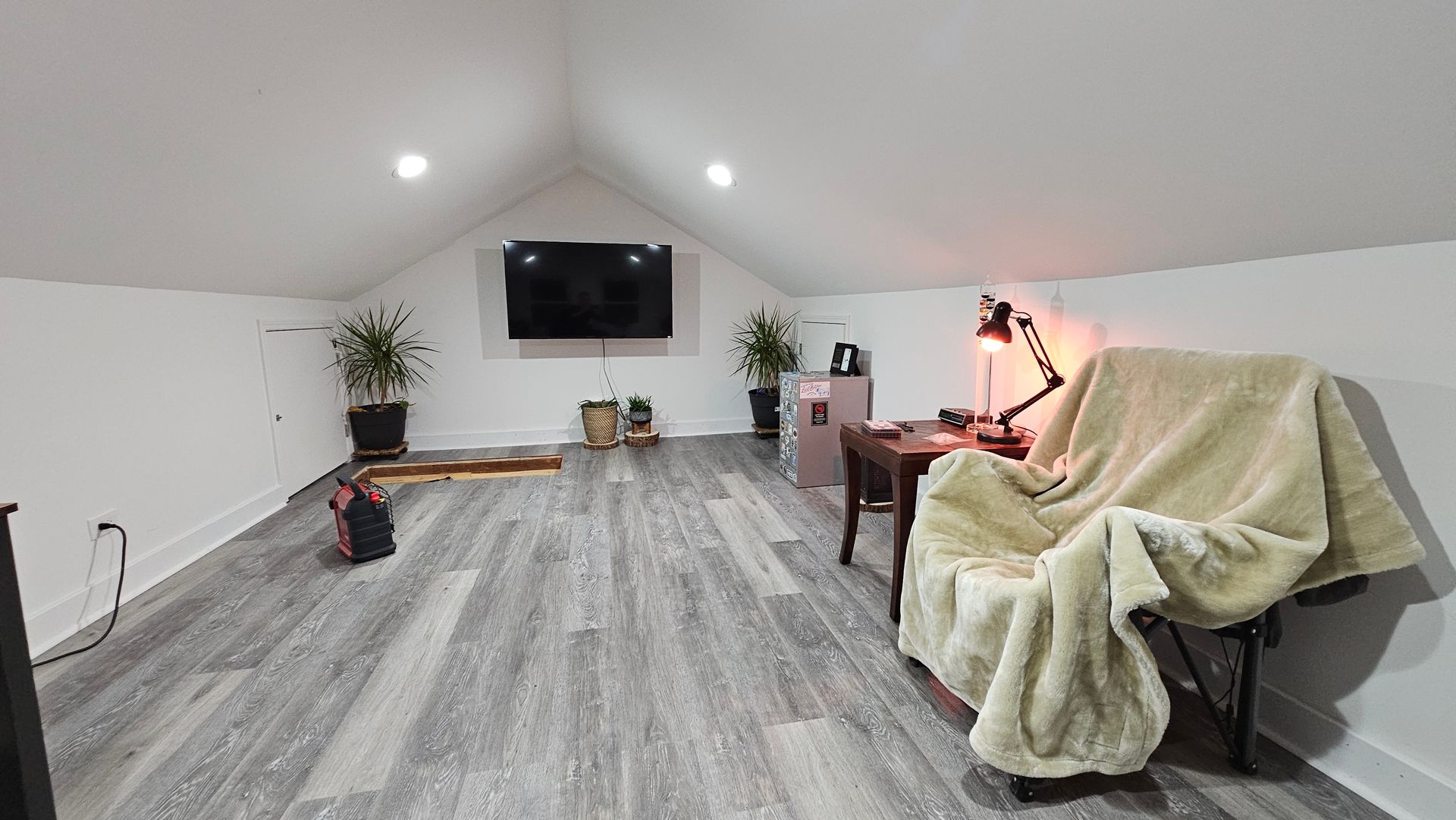 A living room with a couch and a television on the wall.