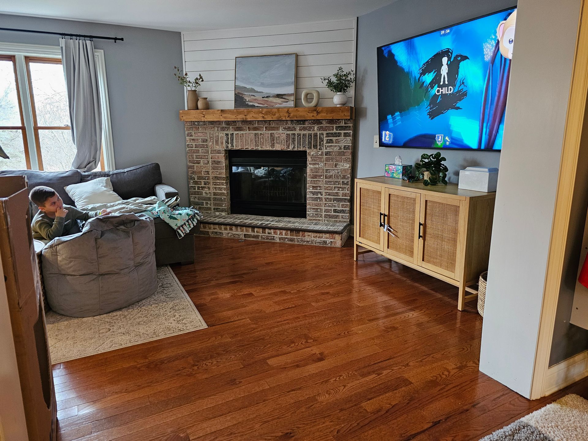 A living room with a fireplace , couch , and television.