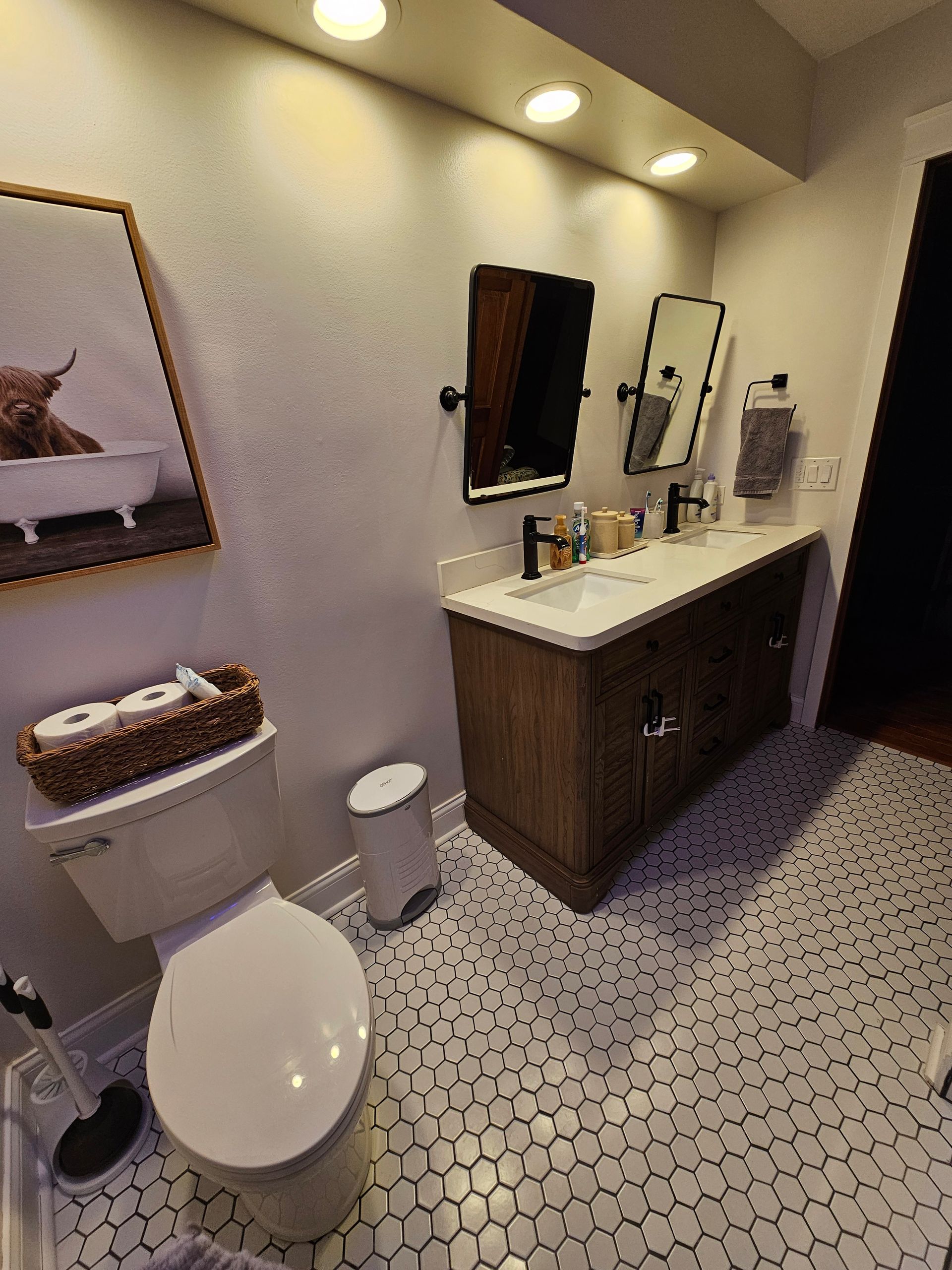 A bathroom with a toilet , sink and mirror.