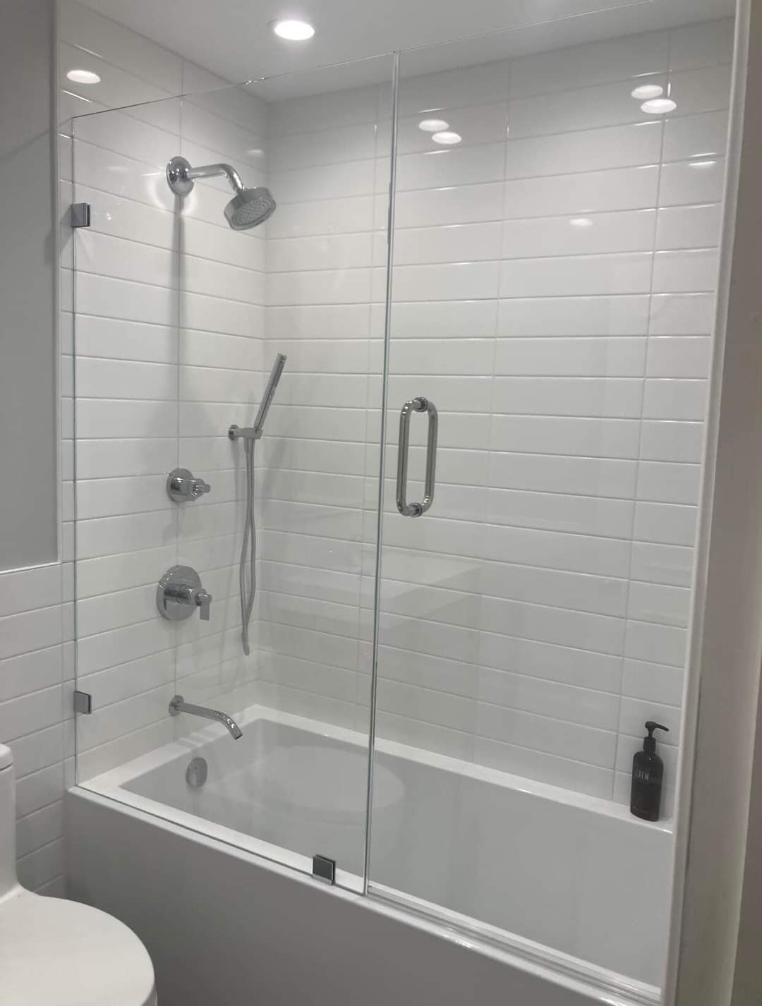 A bathroom with a bathtub and a shower with a glass door.