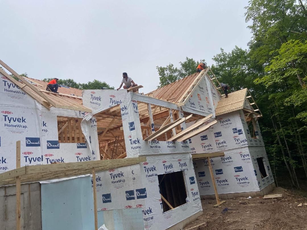 A group of people are working on the roof of a house.