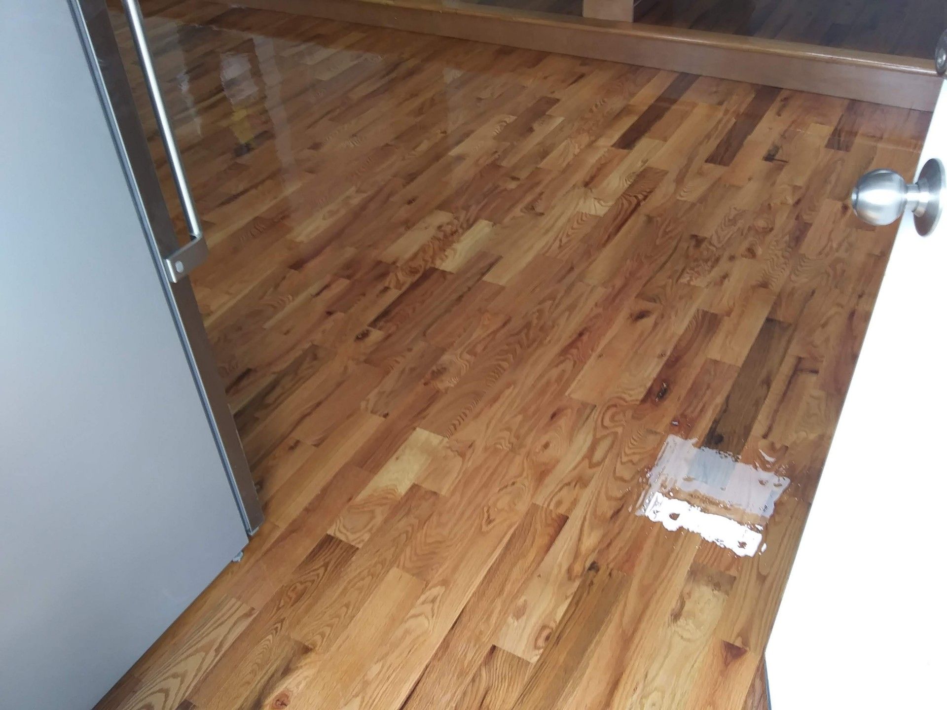 A wooden floor in a room next to a door