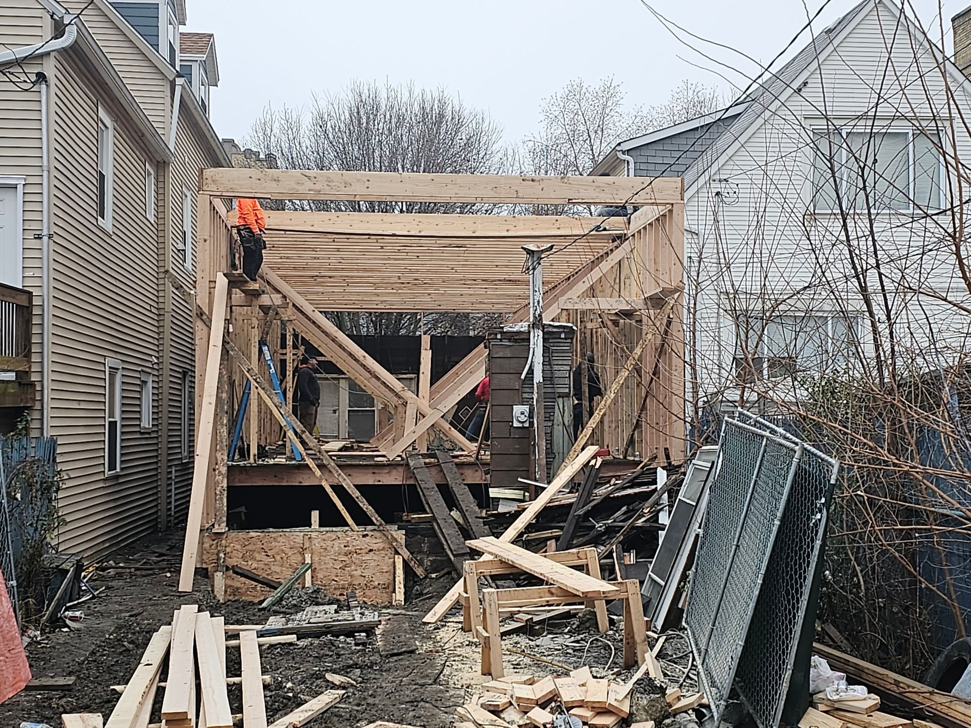 A wooden structure is being built in front of a house.