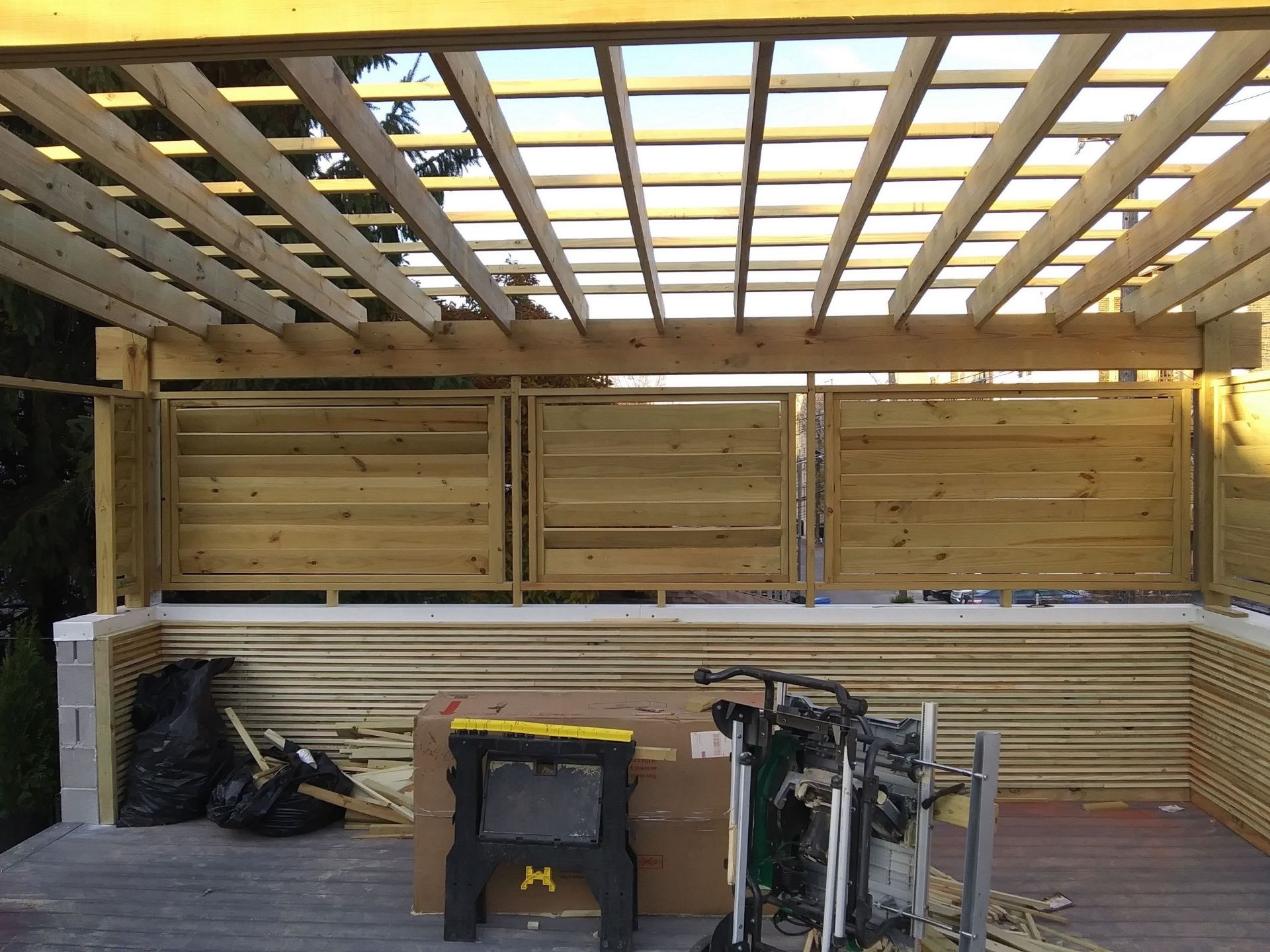 A wooden pergola is being built on a wooden deck.