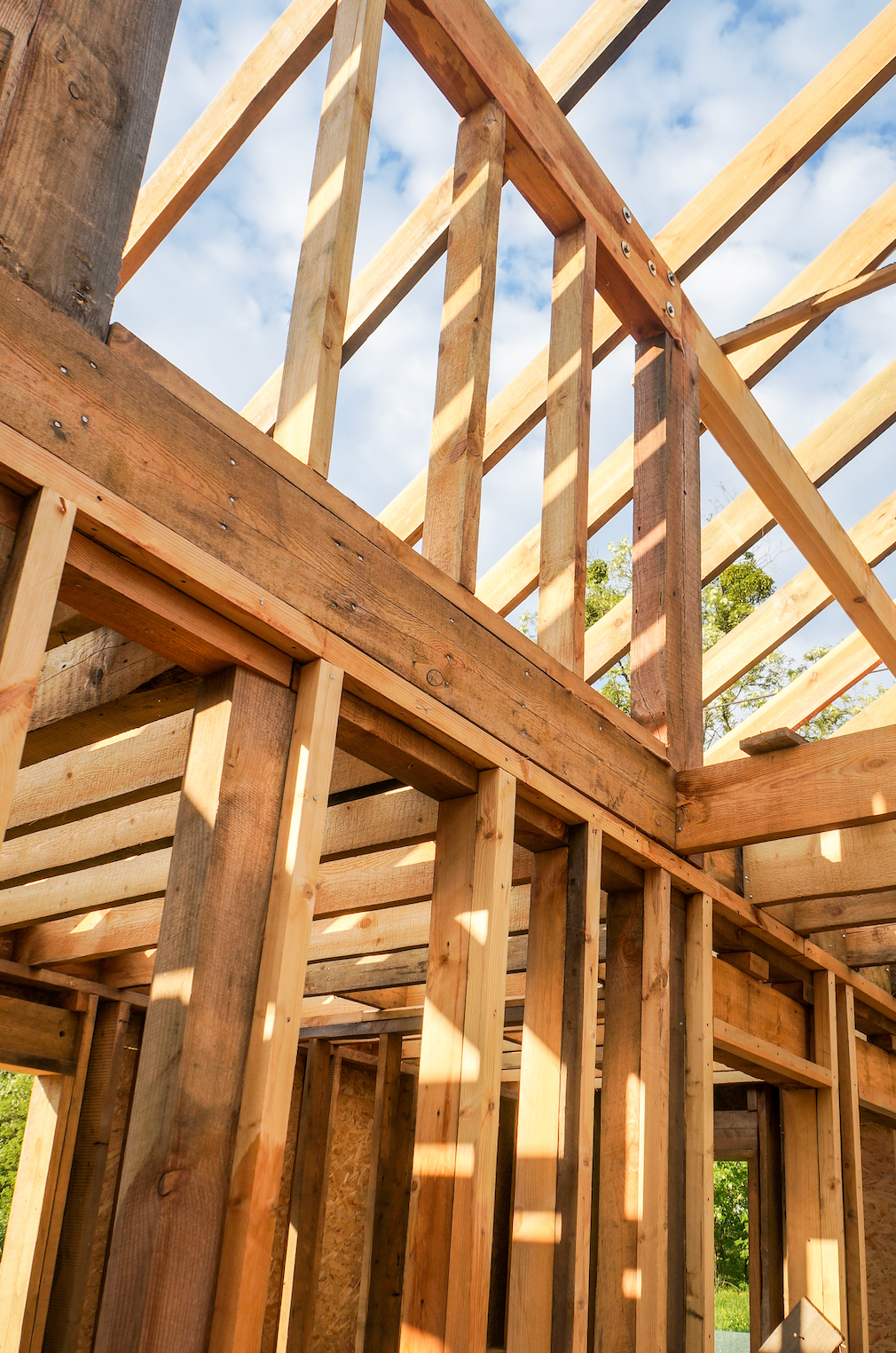 A house is being built with wooden beams and a roof.