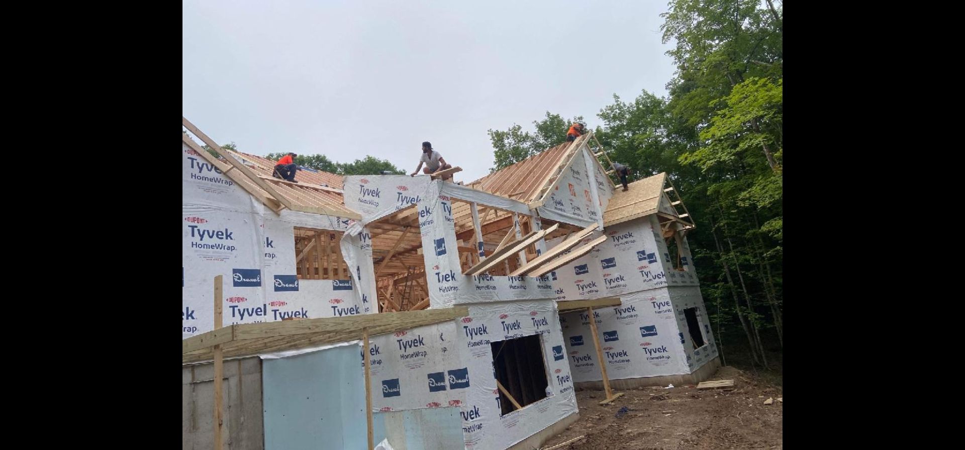 A group of people are working on the roof of a house.