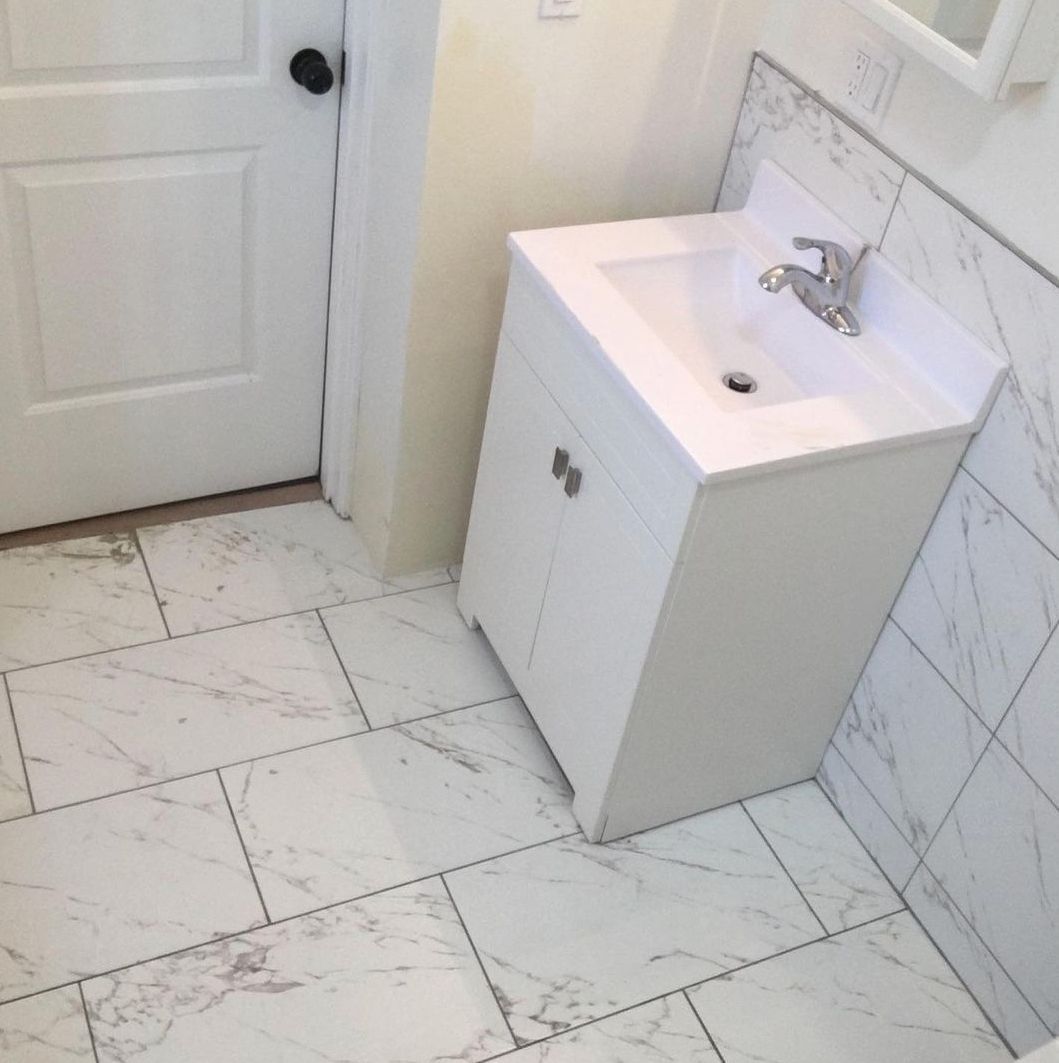 A bathroom with white tiles and a sink
