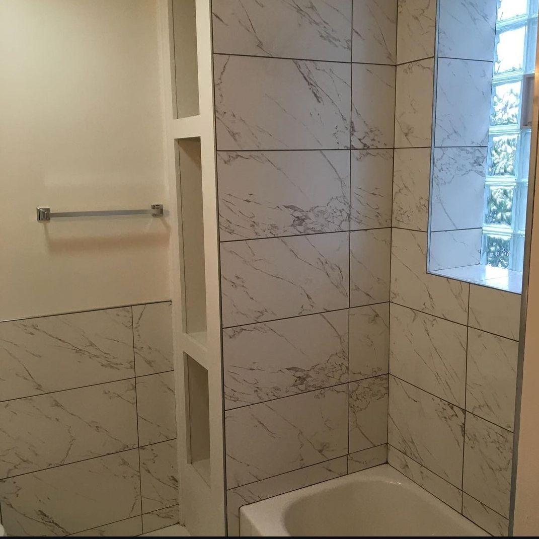 A bathroom with marble tiles and a window
