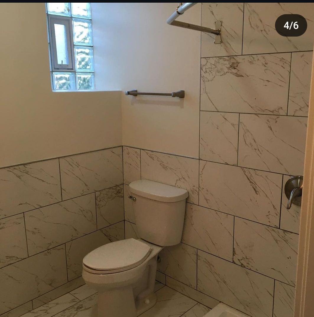 A bathroom with a toilet and a window with the number 4/6 in the corner