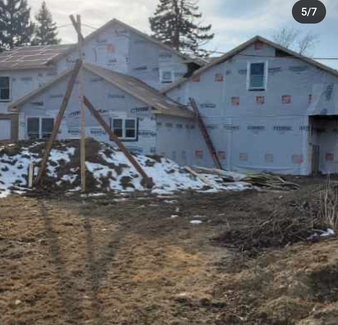 A house is being built in the middle of a dirt field.