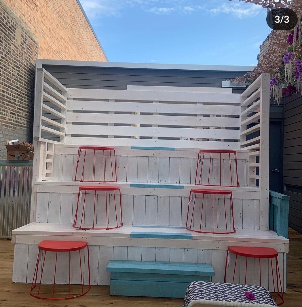 A row of stools are lined up in front of a fence with the number 3 on it