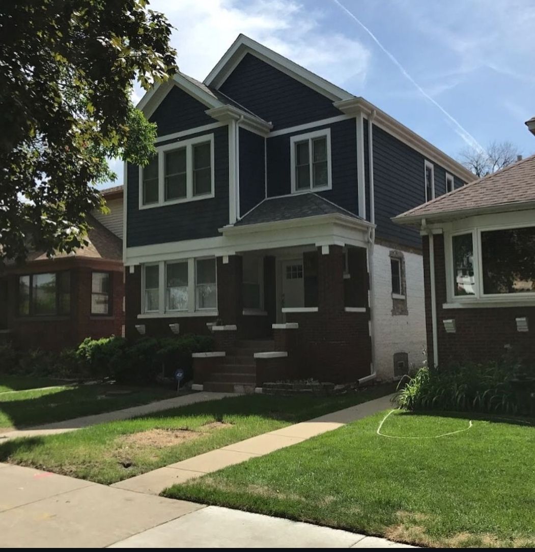 A large house with a blue siding and white trim