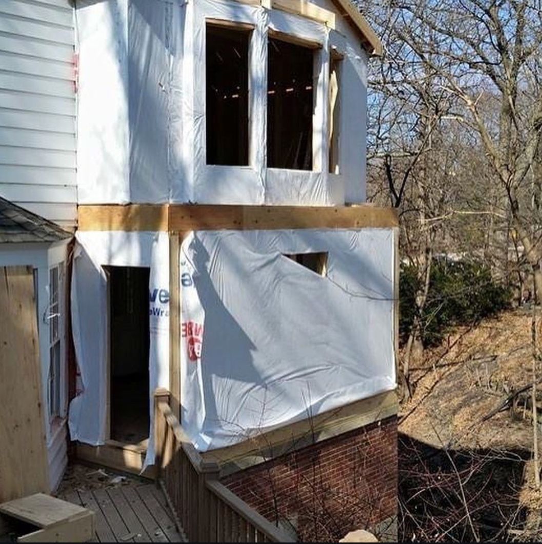 A house that is being remodeled with a lot of trees in the background
