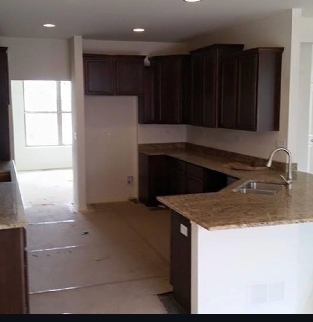 A kitchen with brown cabinets and granite counter tops