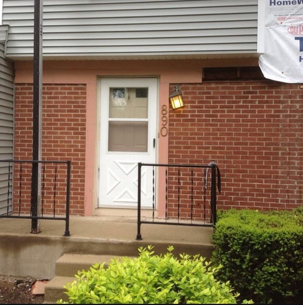 A brick building with a white door and a sign that says home