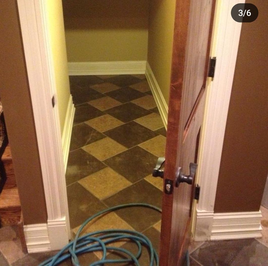 A door is open to a hallway with a checkered floor