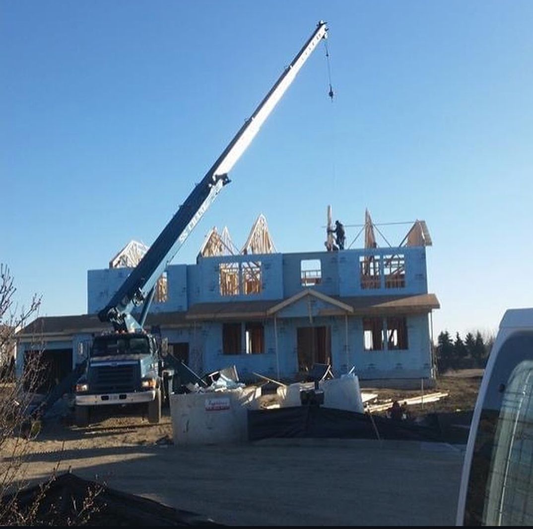 A large crane is being used to build a house