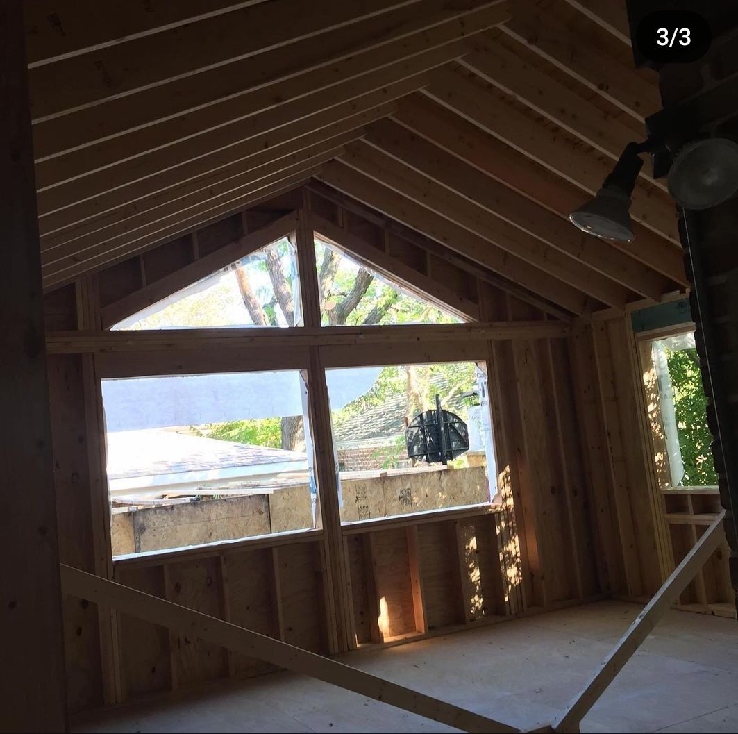 A room with a vaulted ceiling and lots of windows