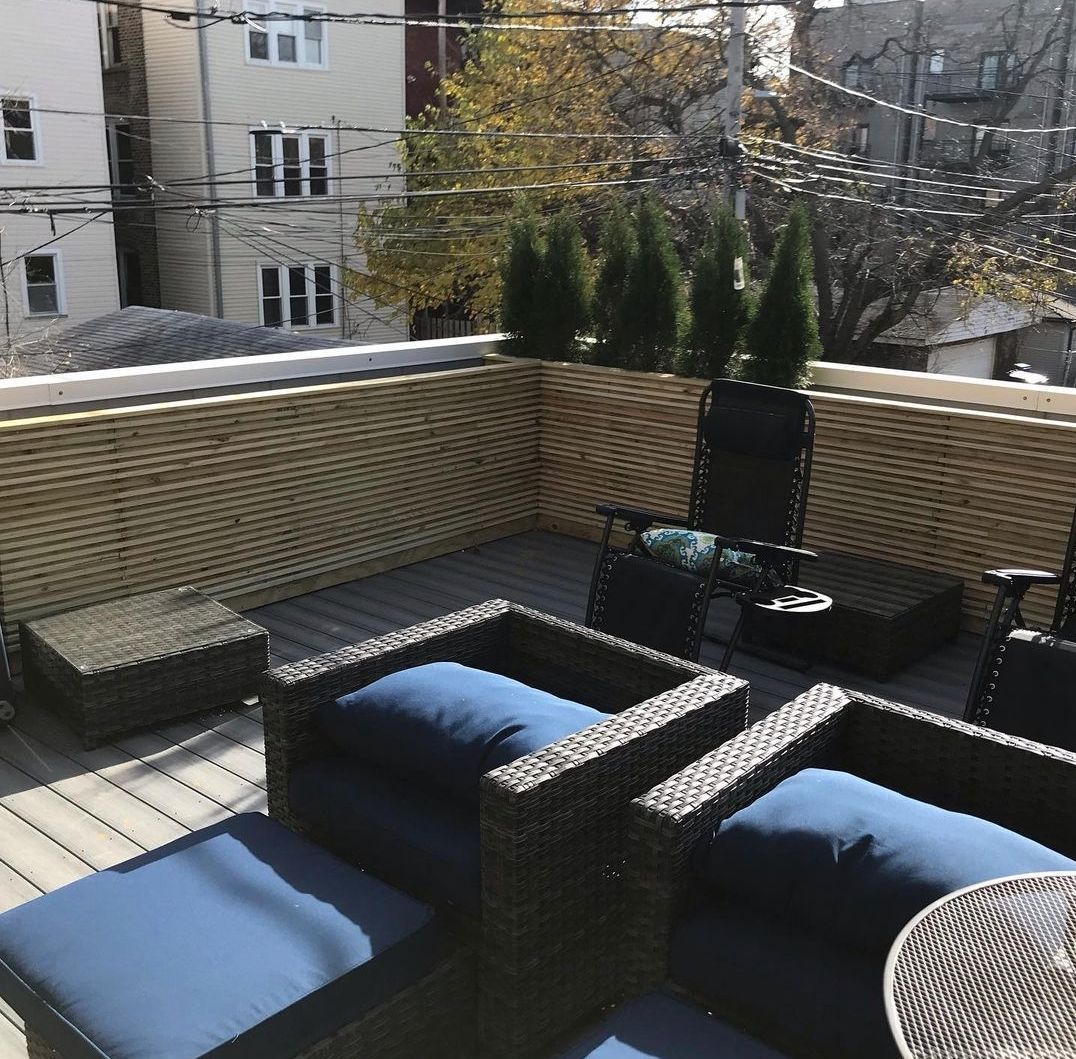 A balcony with wicker furniture and blue cushions