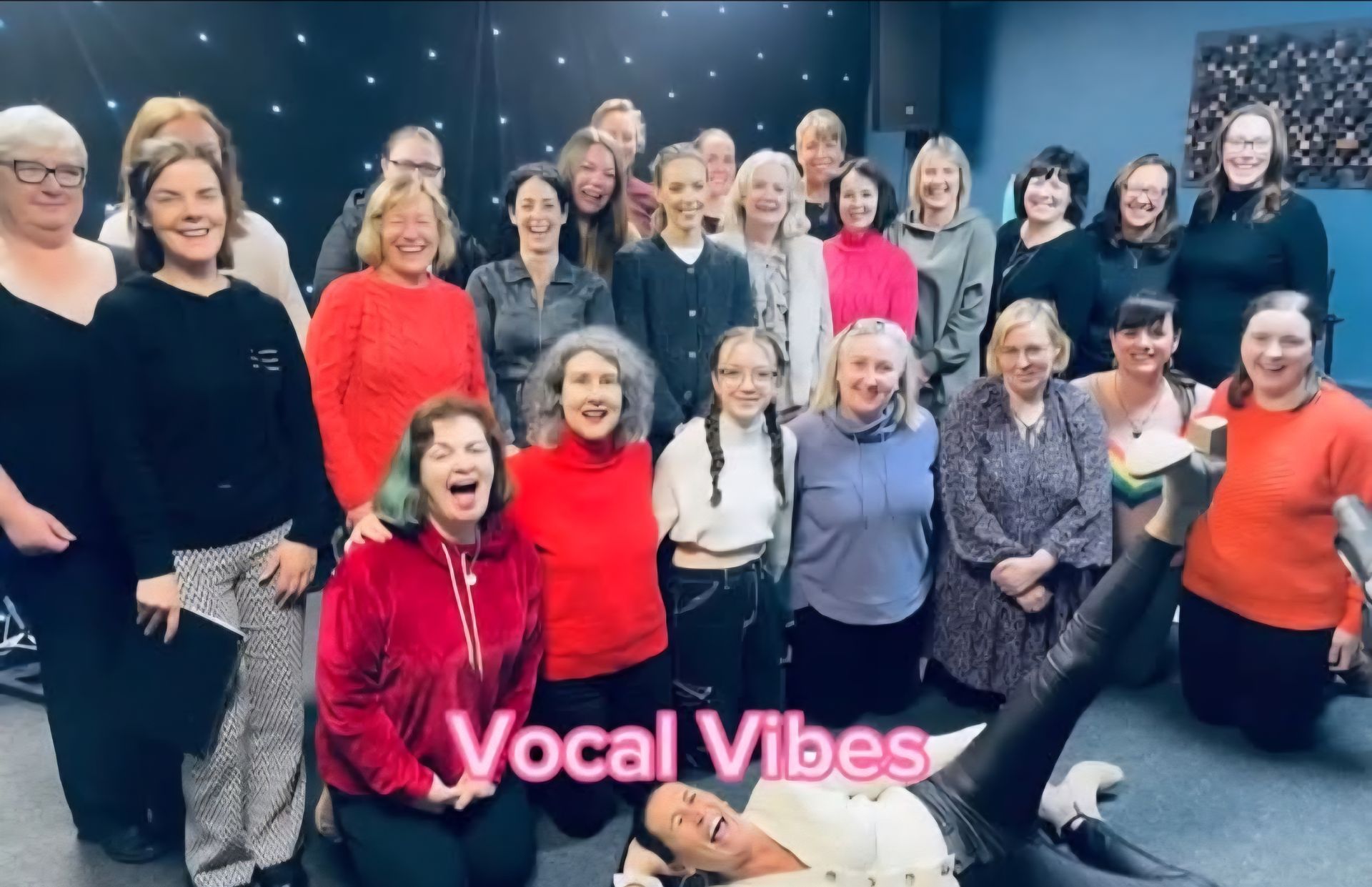 A large group of people smiling and laughing for a photo, with the text 