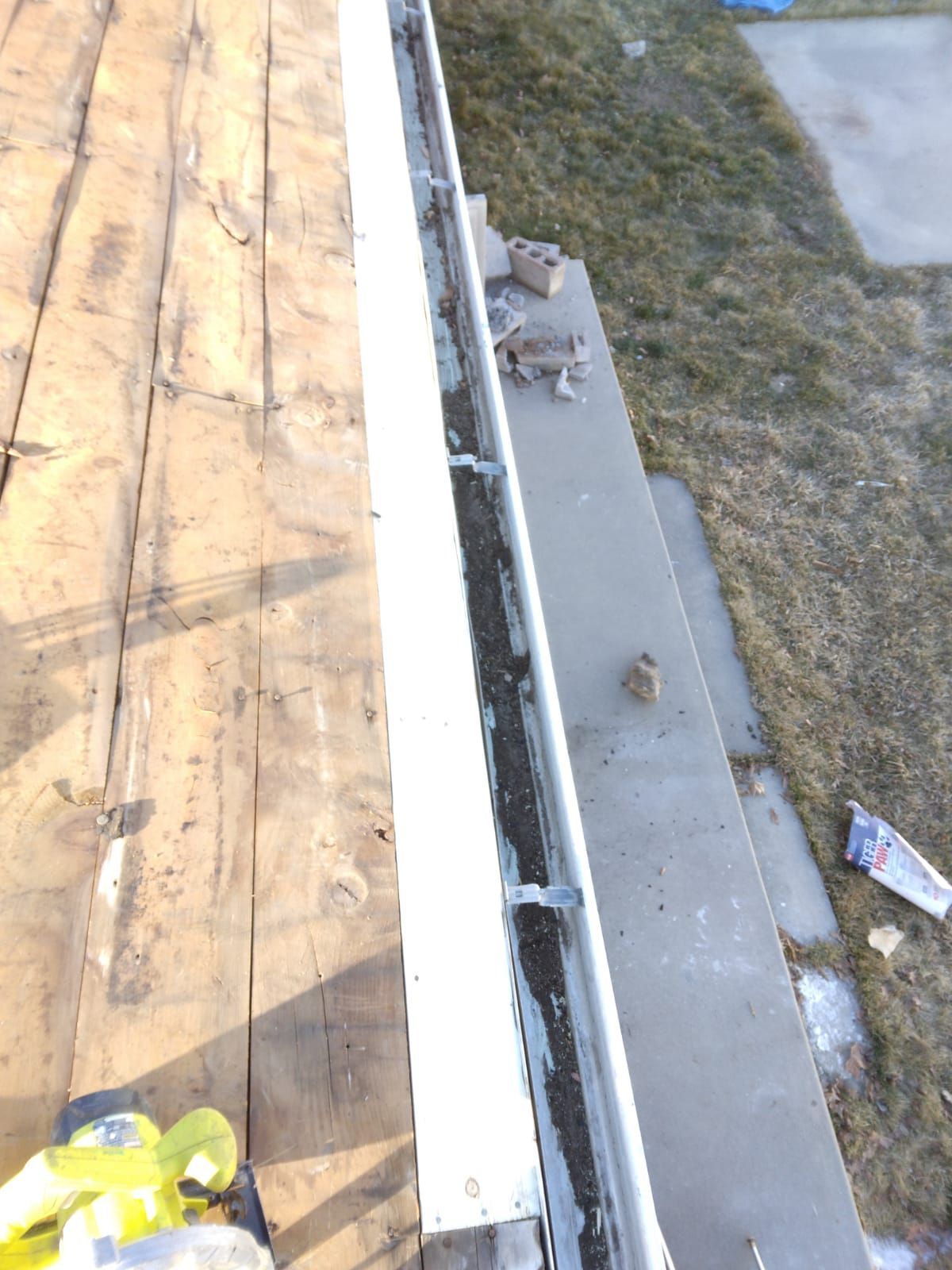 A gutter is being installed on a wooden deck