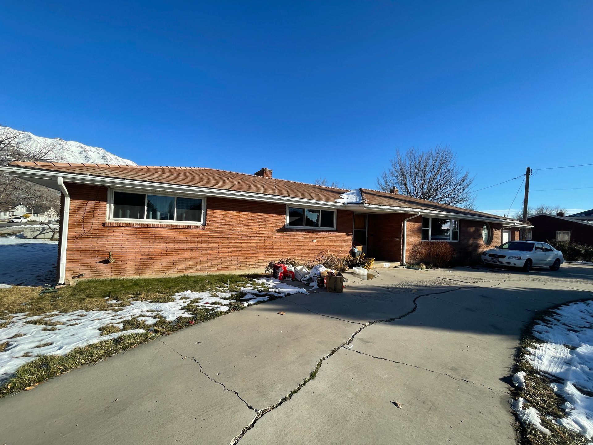 A brick house with a car parked in front of it.