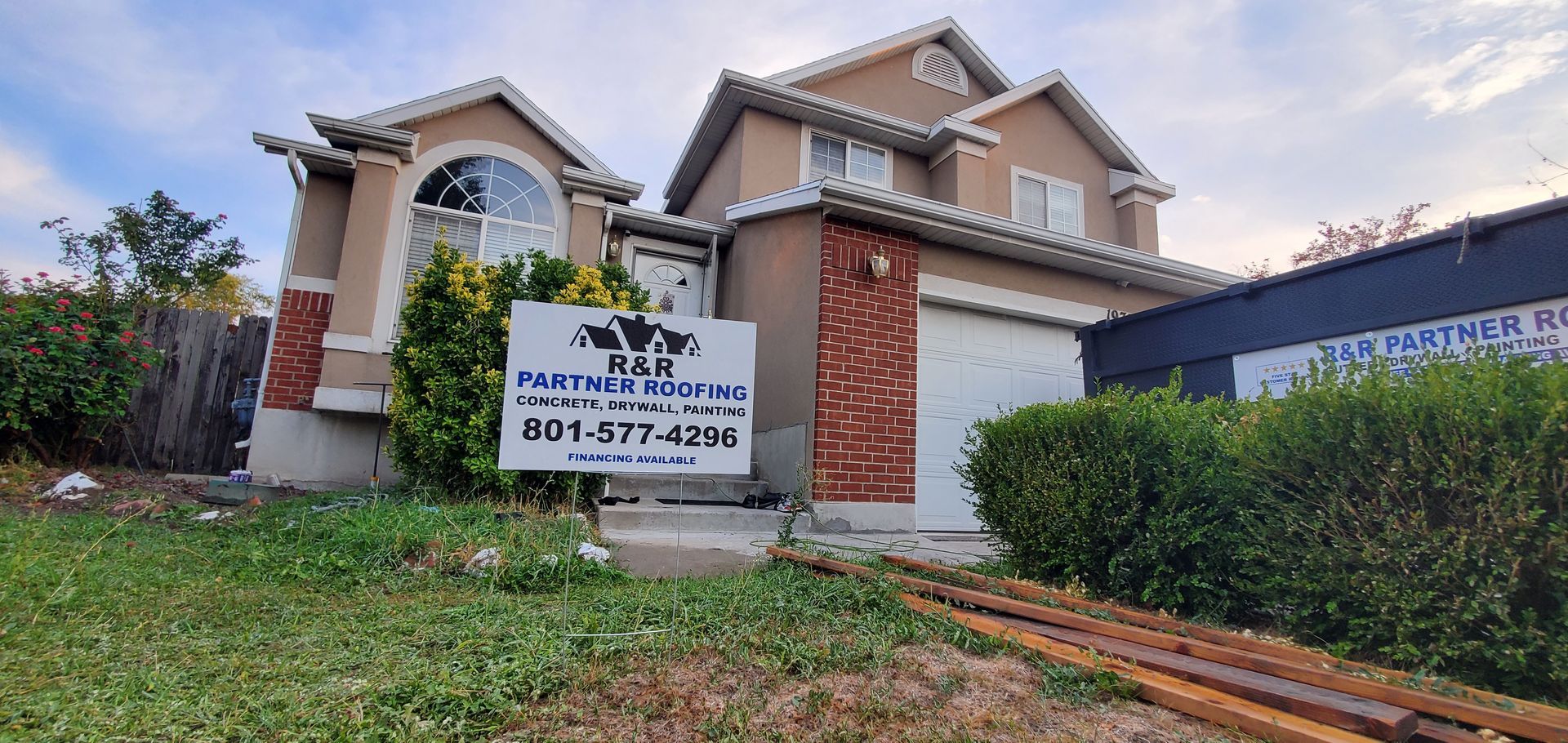 A large house with a for sale sign in front of it.