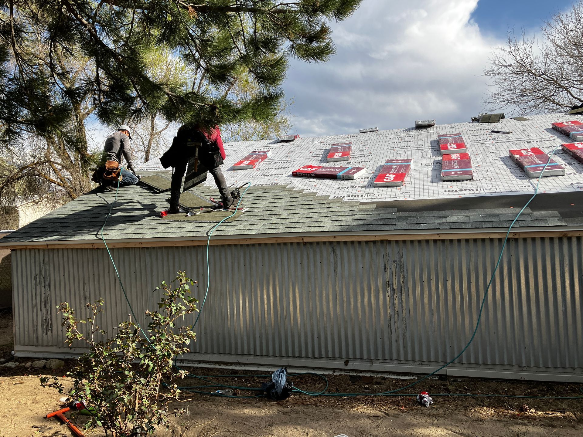 Two men are working on the roof of a building.