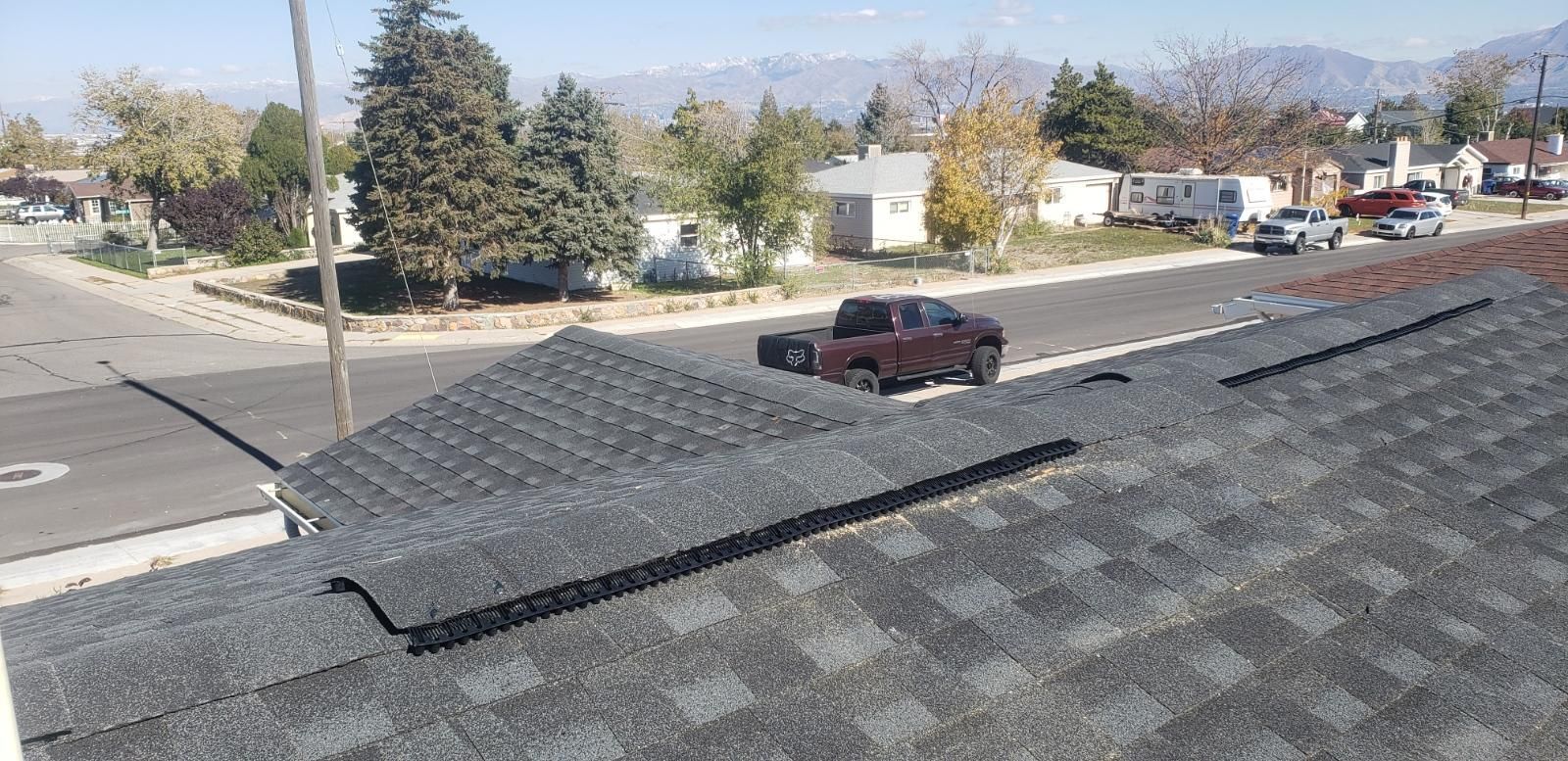 A truck is parked on the roof of a house in a residential area.