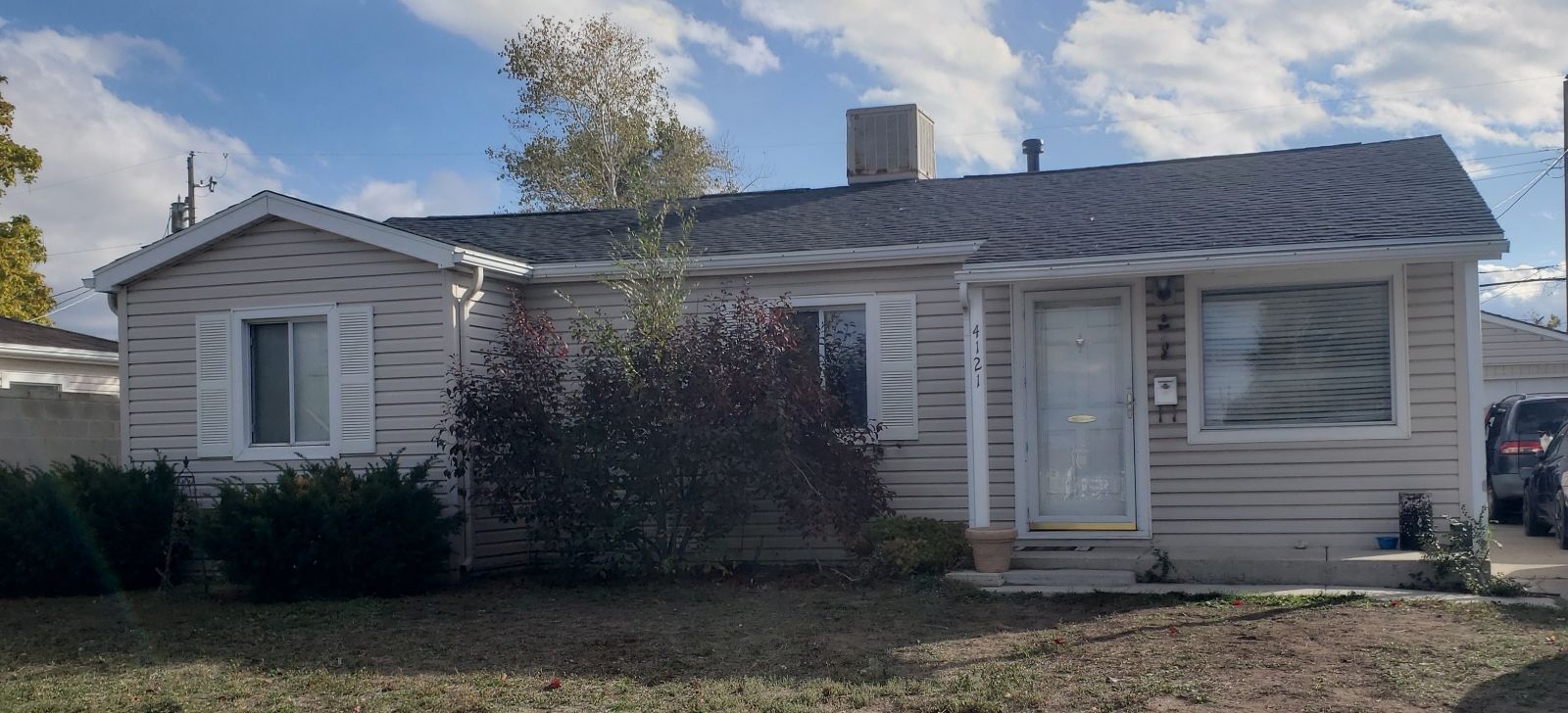 A small house with a car parked in front of it.
