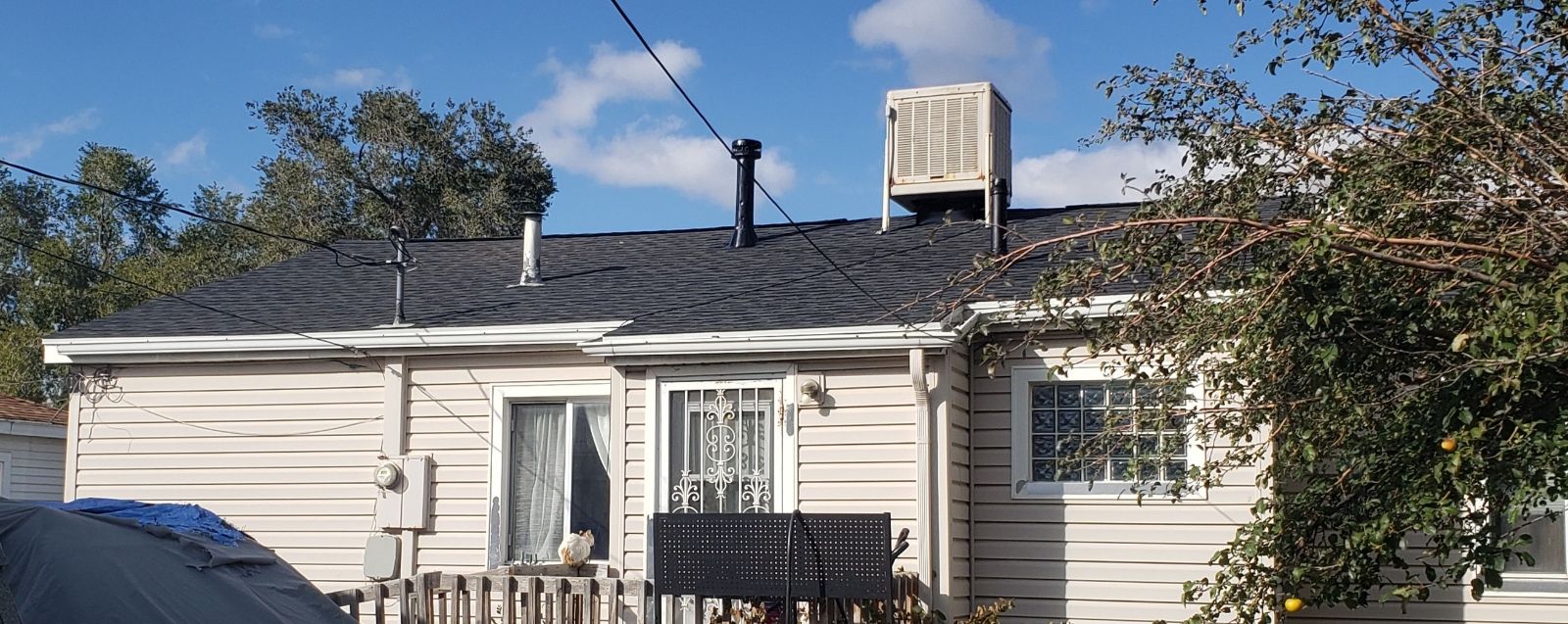 A white house with a black roof and a chimney