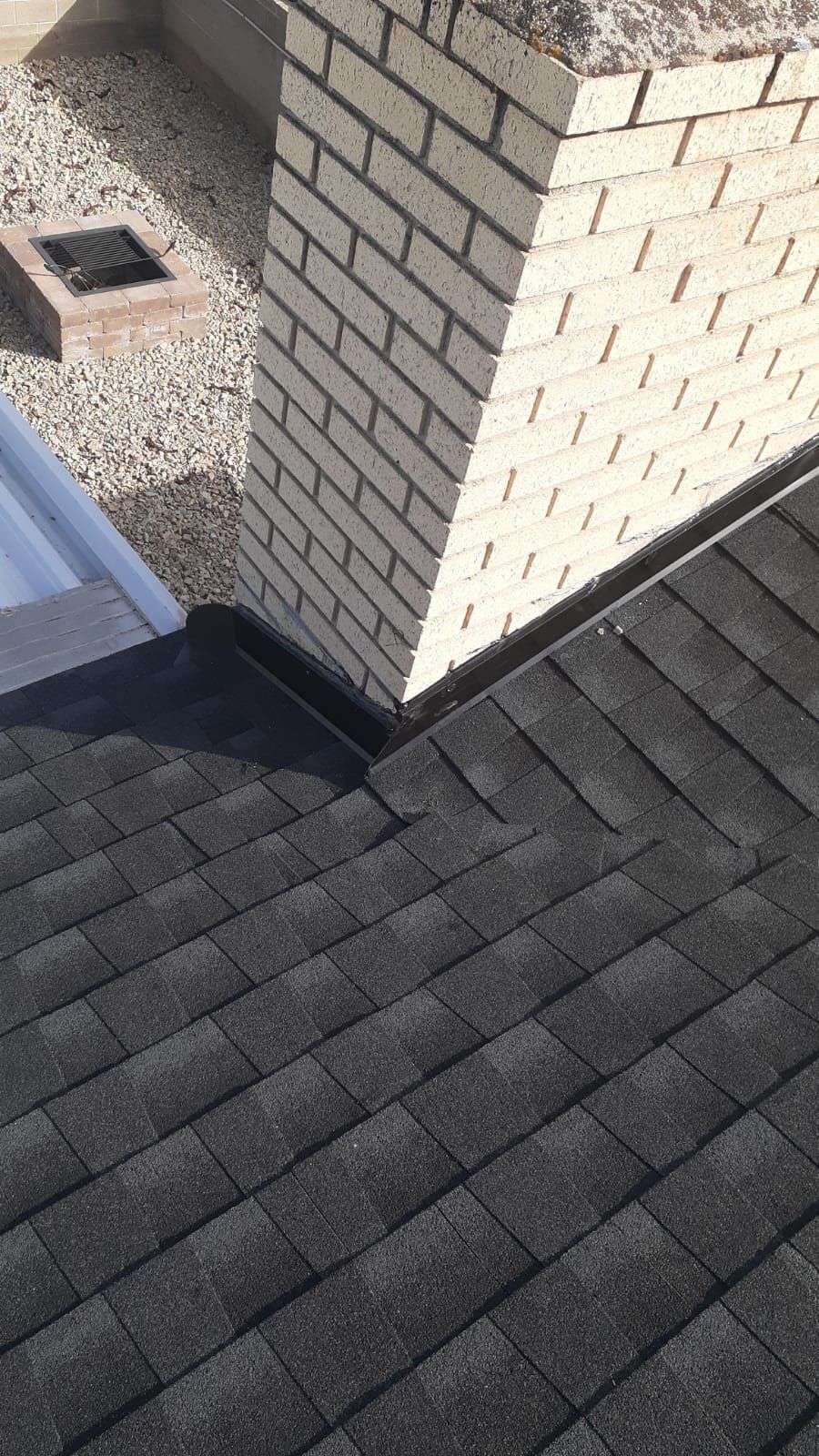 A close up of a roof with a chimney on top of it.