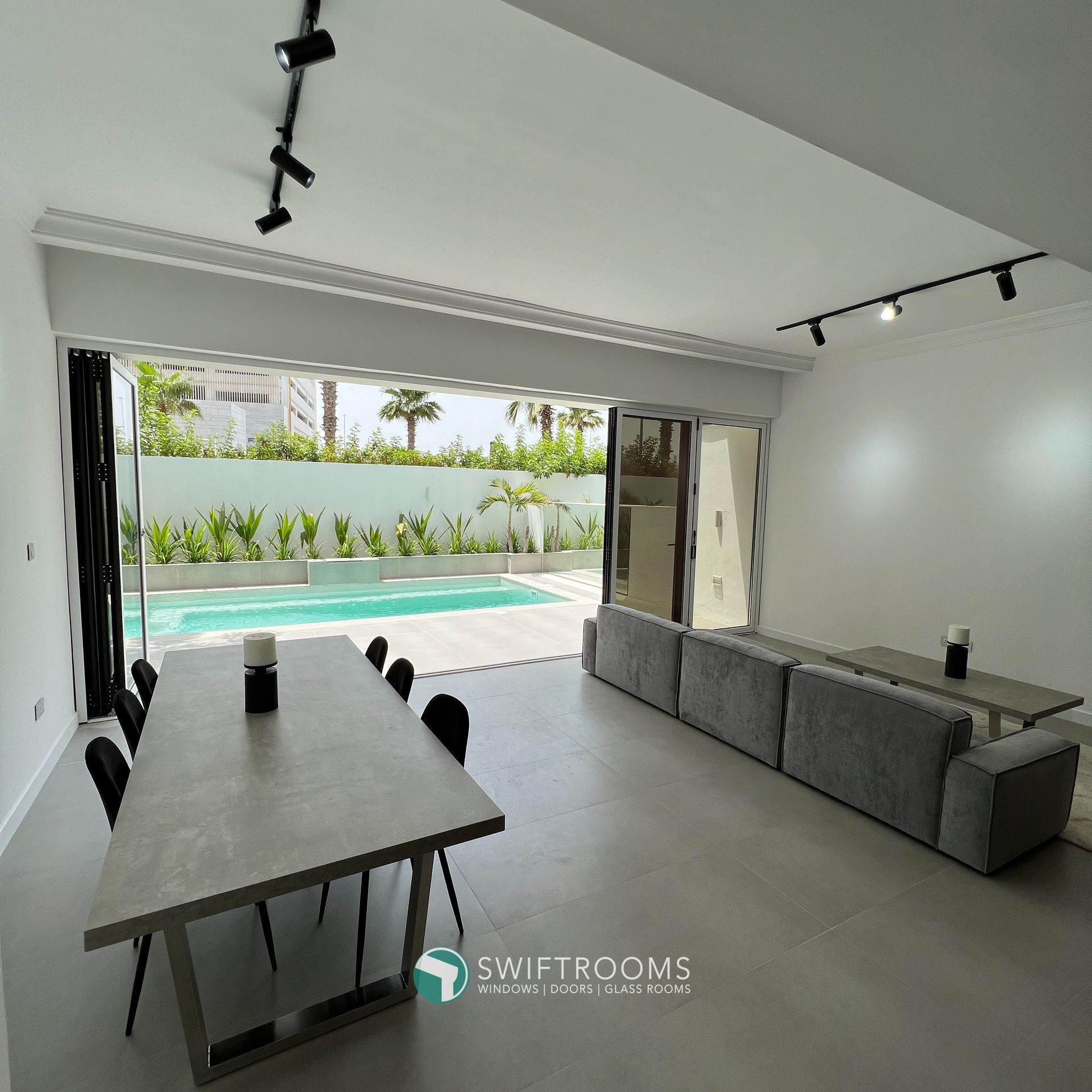 A living room with a sliding glass door leading to a swimming pool