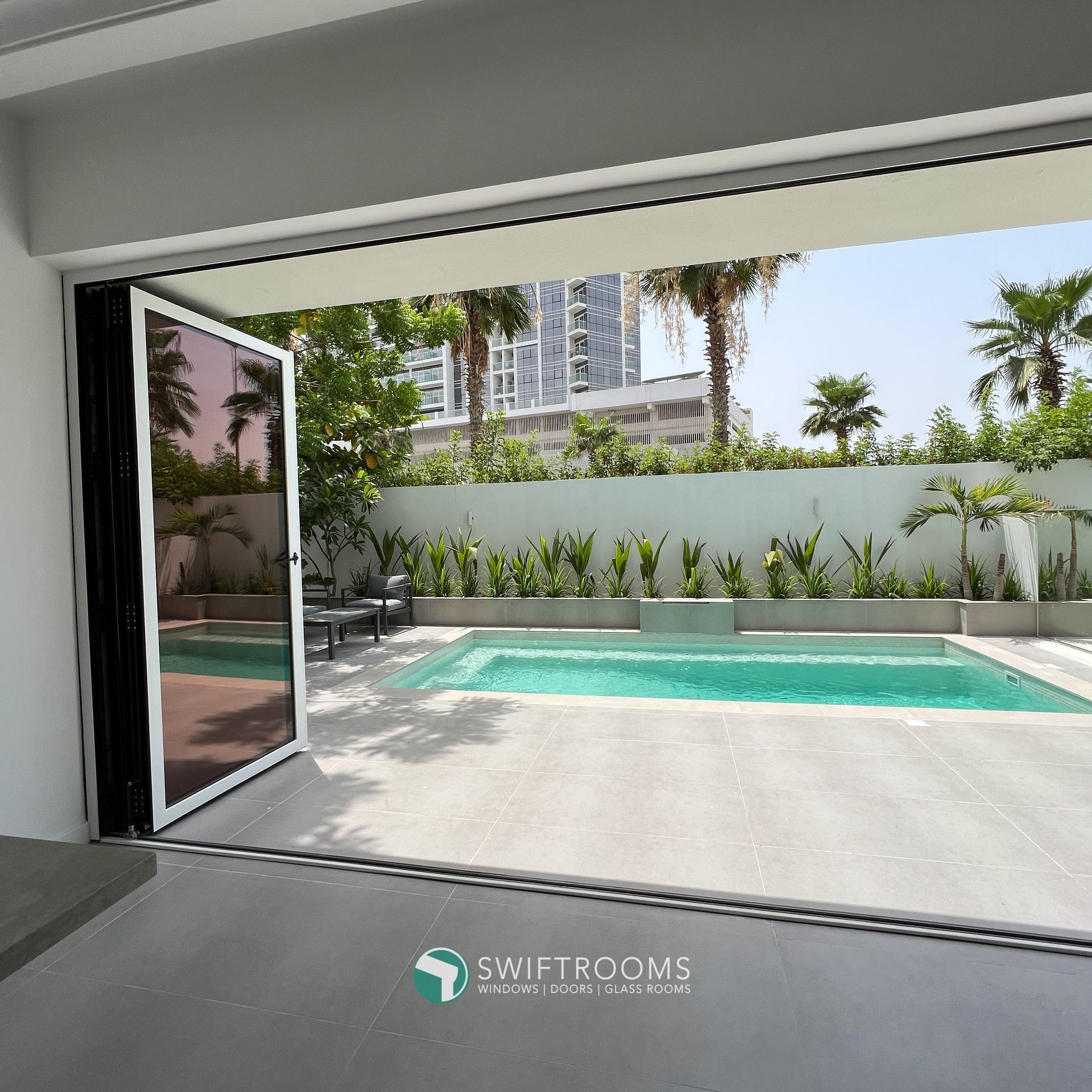 A swimming pool is visible through a sliding glass door