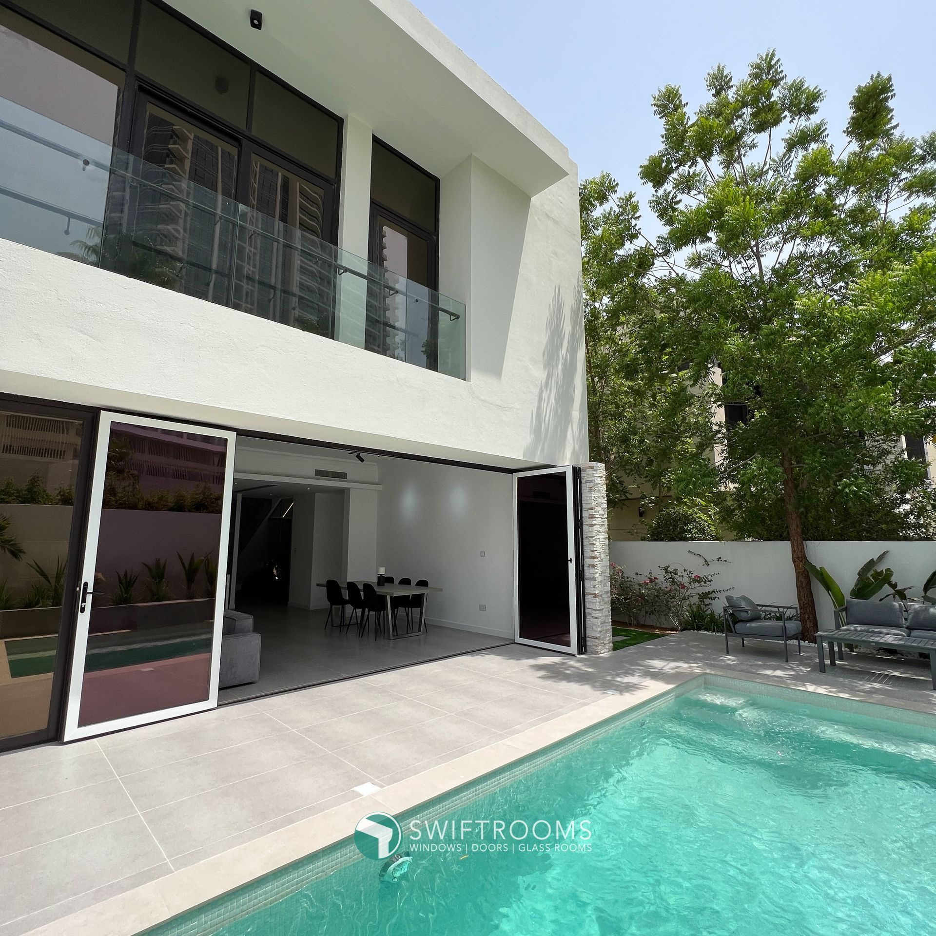 A large white house with a swimming pool in front of it