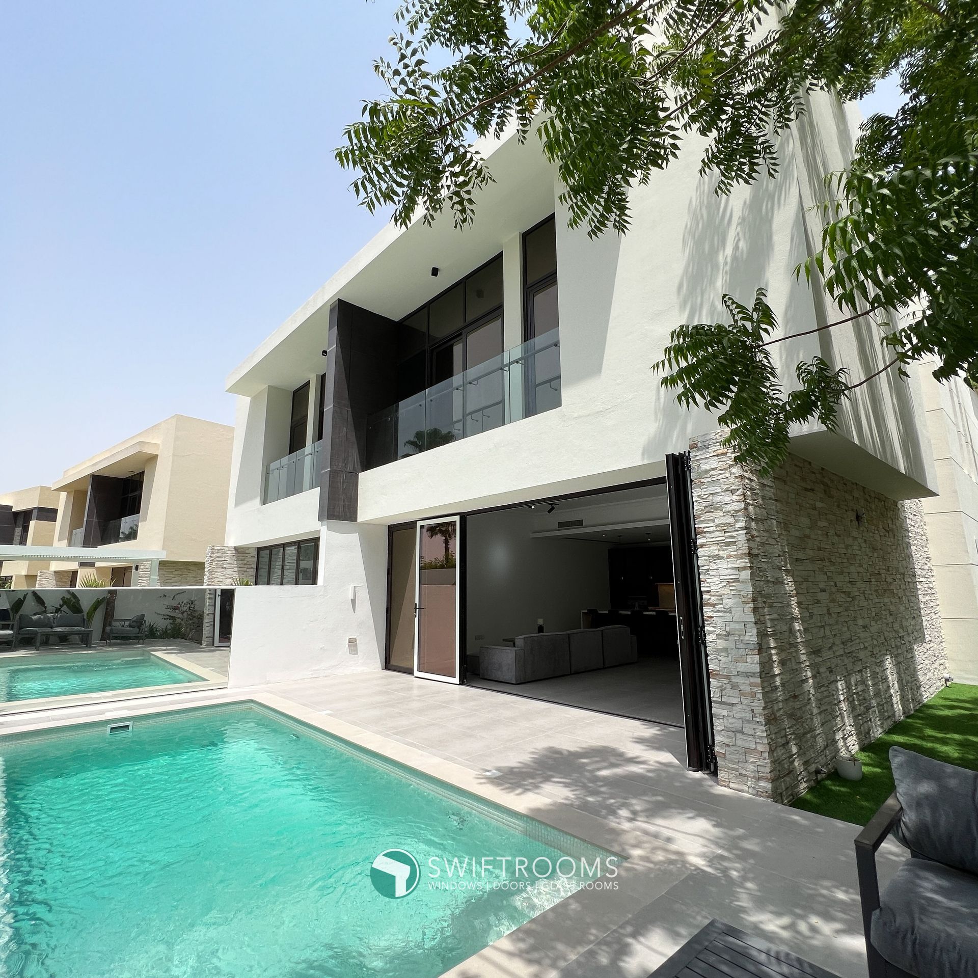 A large white house with a swimming pool in front of it