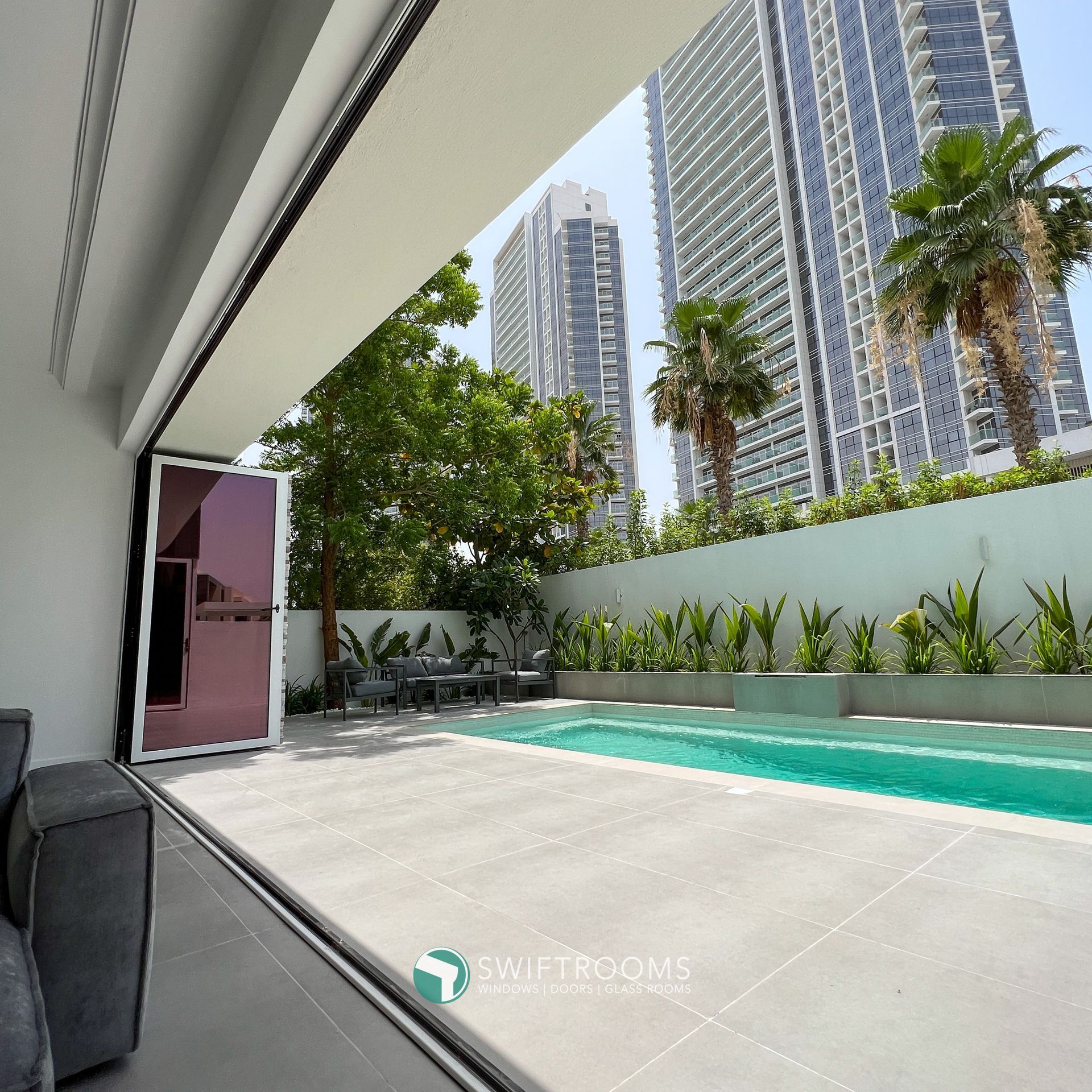 A large swimming pool is surrounded by tall buildings