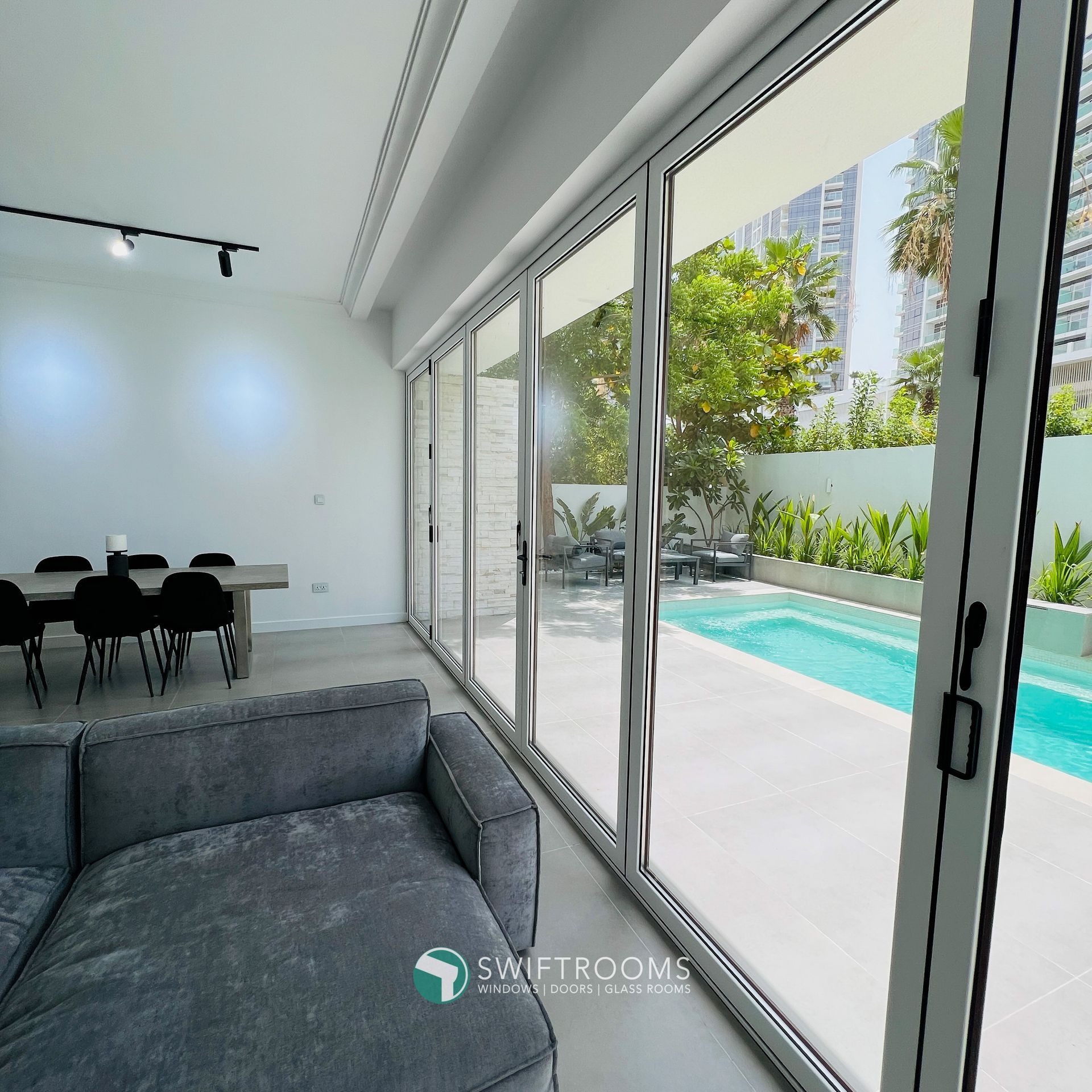 A living room with sliding glass doors leading to a swimming pool