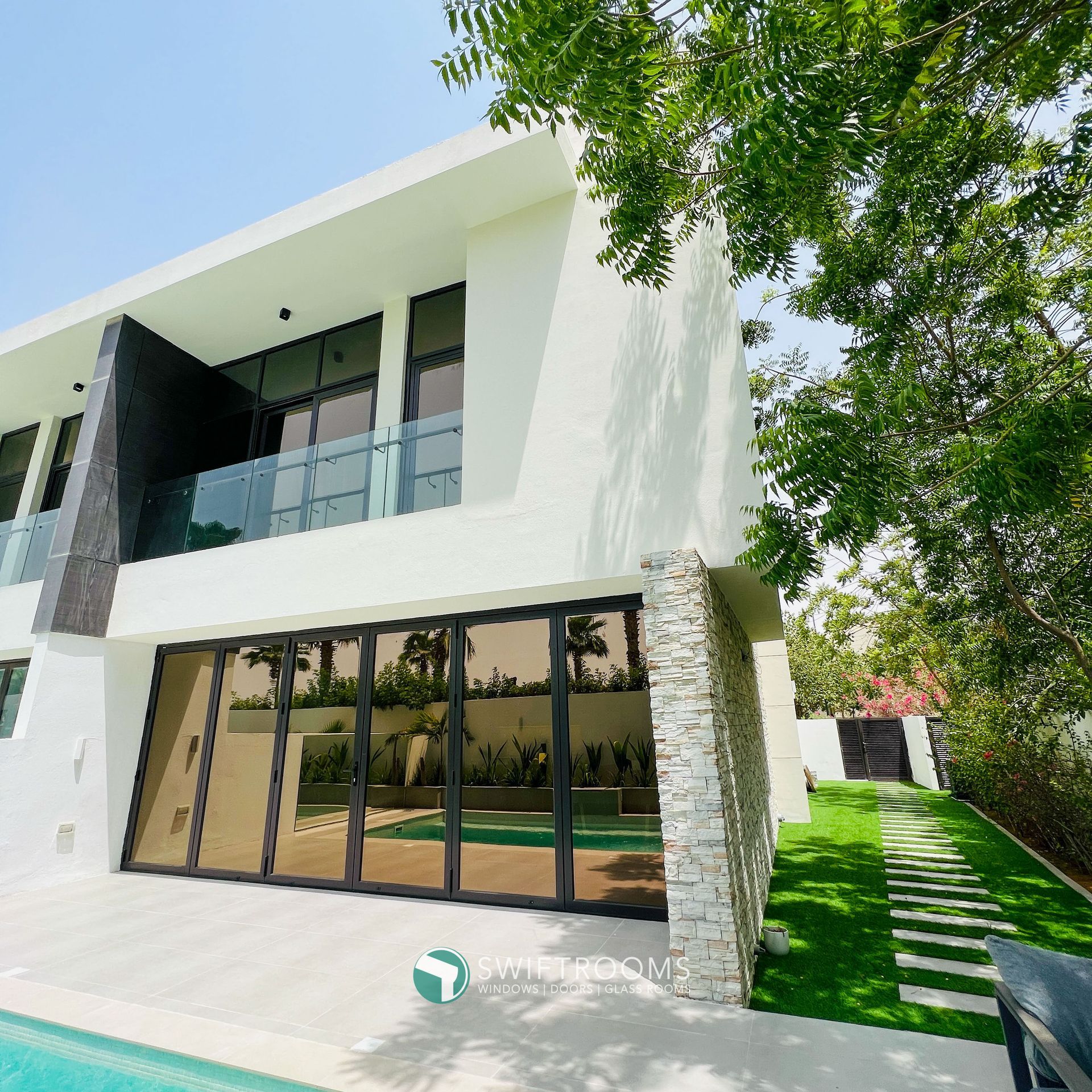 A large white house with a swimming pool in front of it