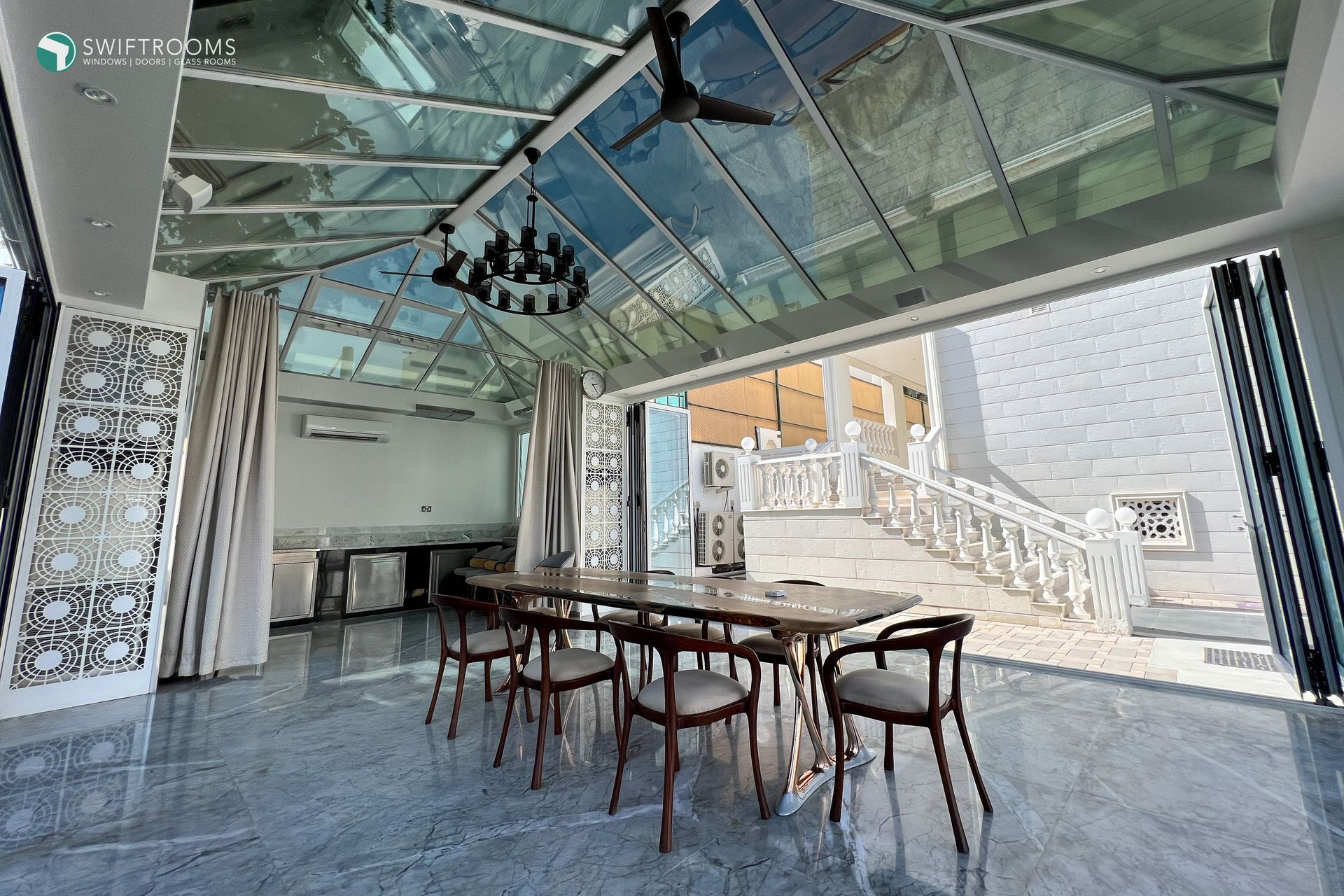 A dining room with a table and chairs under a glass ceiling.