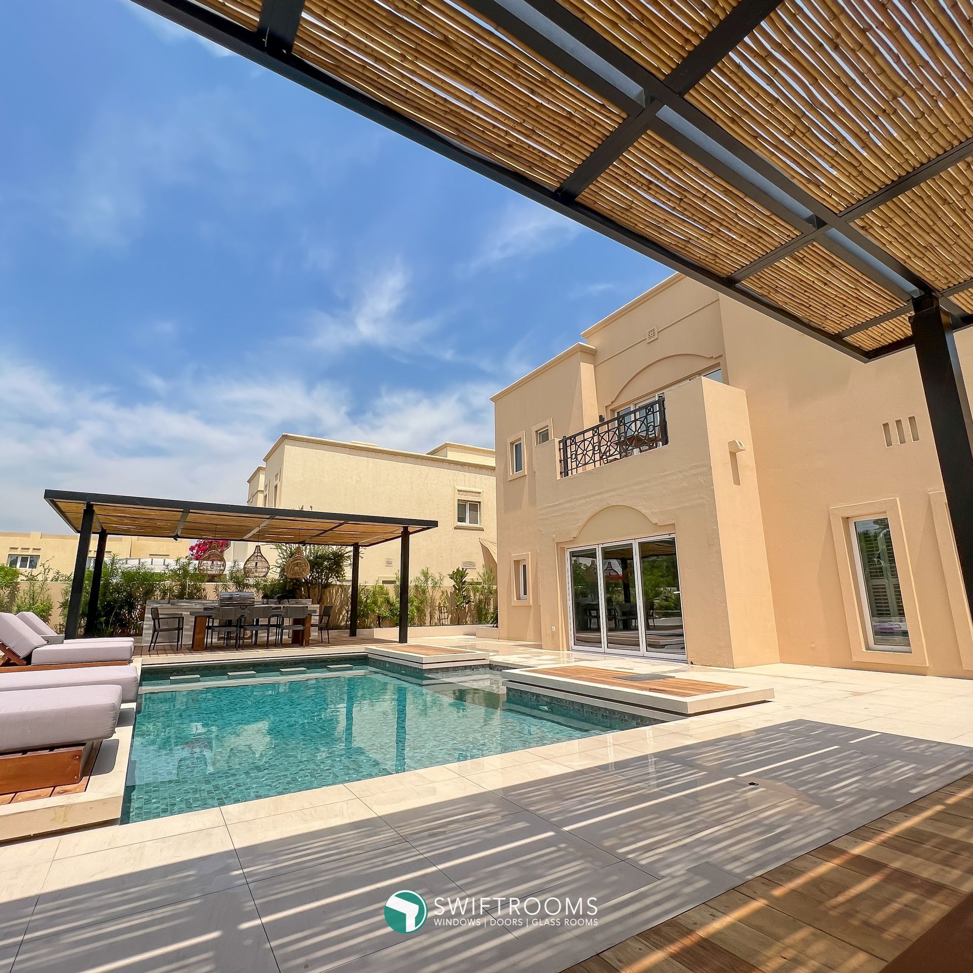 A large house with a swimming pool in front of it.