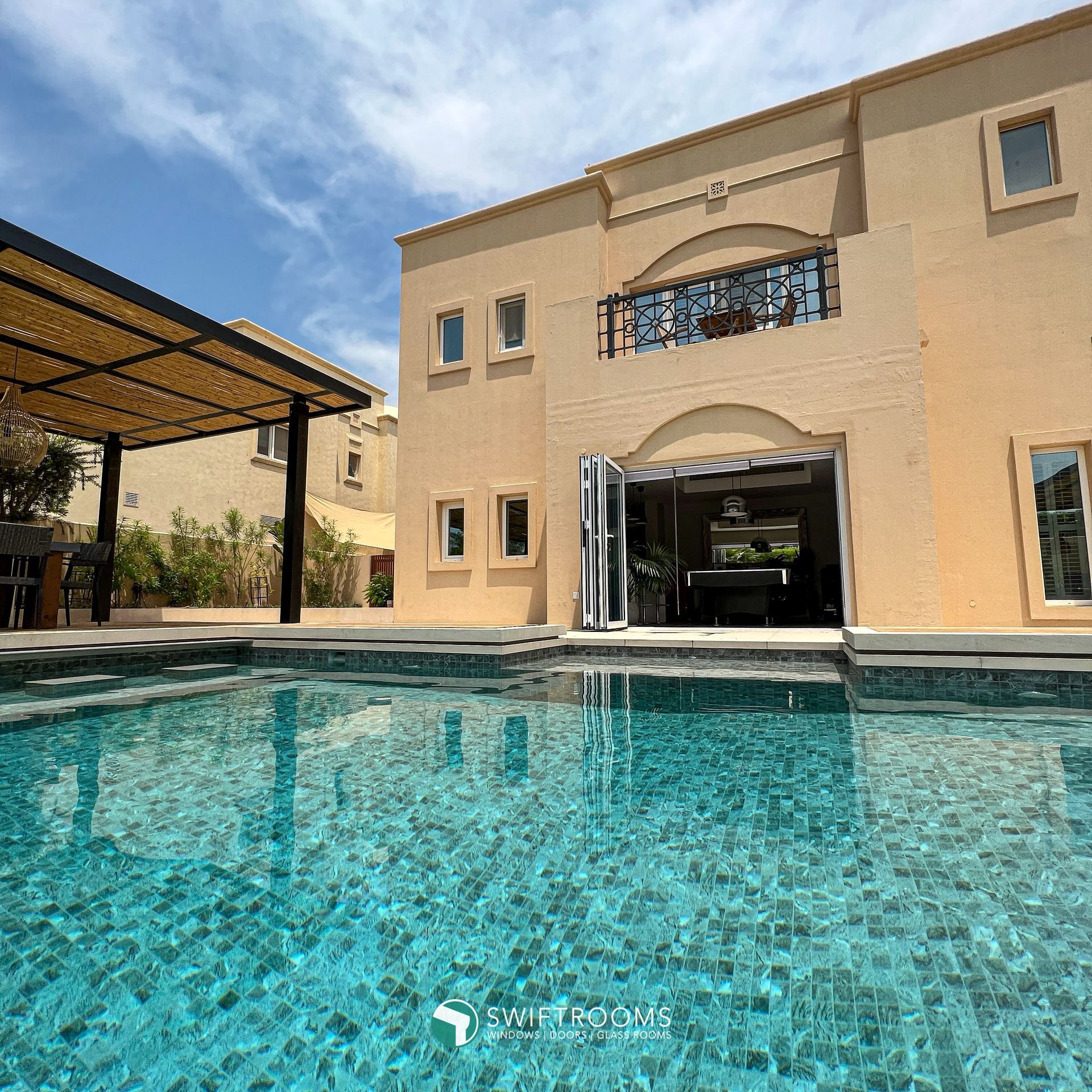 A large house with a swimming pool in front of it